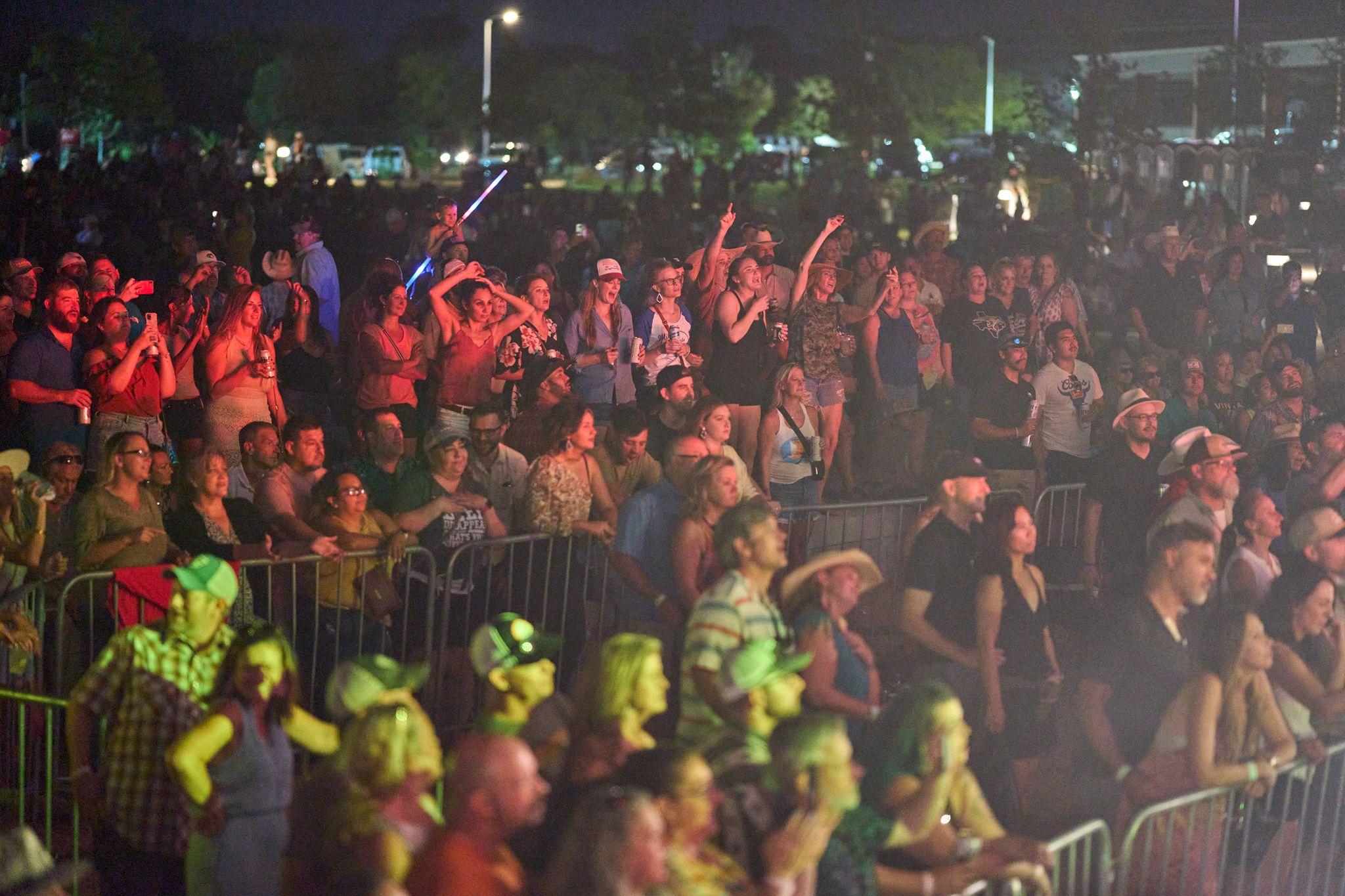 Packed outdoor crowd with hands raised in front of a stage — Live music photography, Austin Live Performances & Concerts