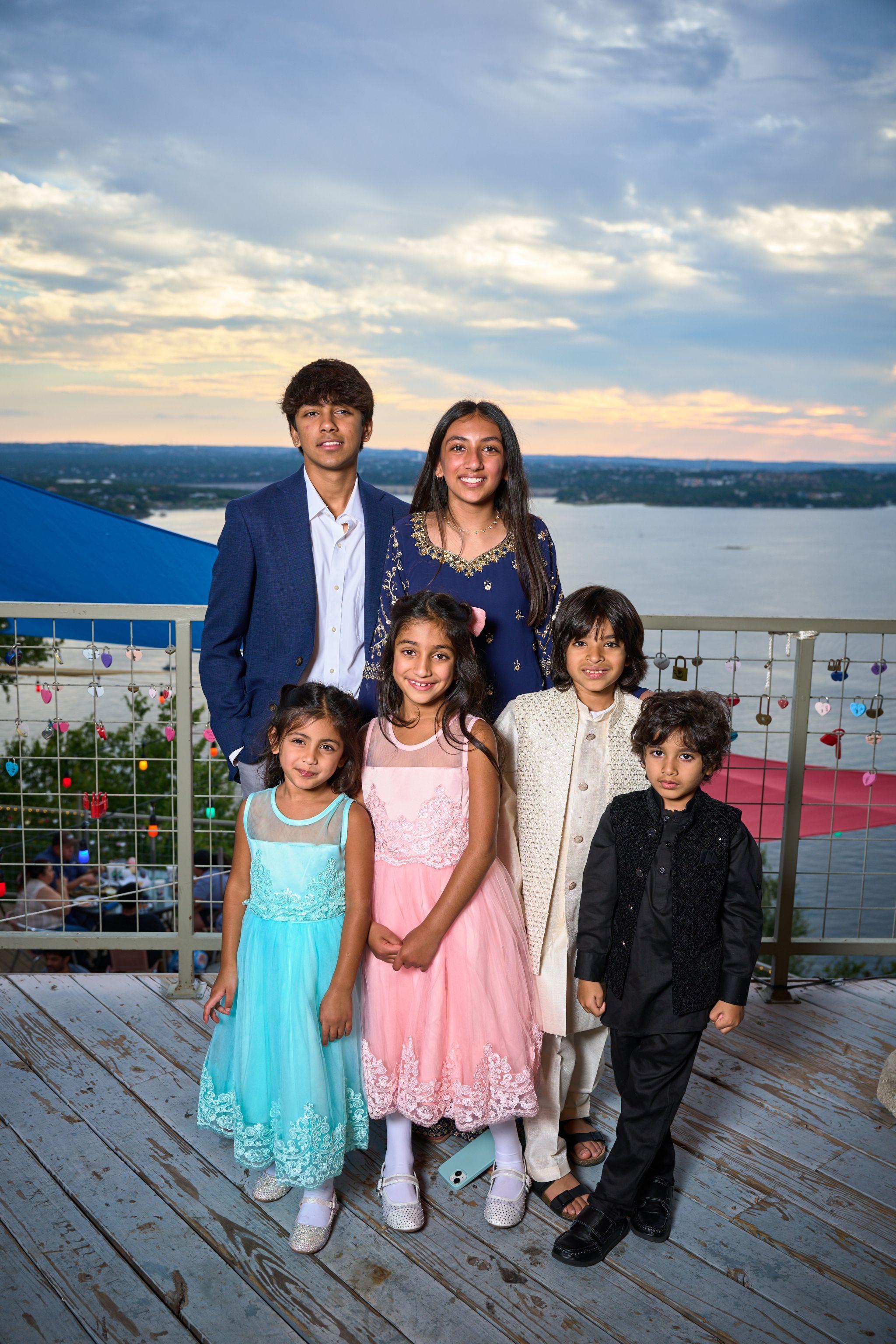 Family in formal dress posed on a deck at sunset above Lake Travis — The Oasis on Lake Travis photography, Austin A family in formal dress posed on a deck at sunset above Lake Travis.