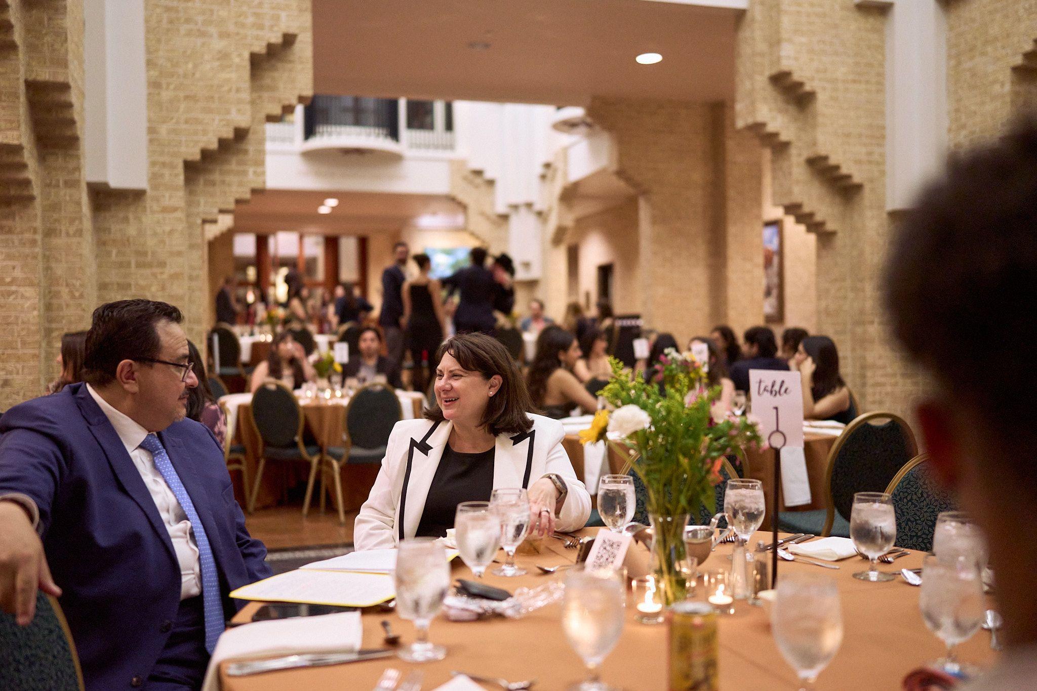 Guests seated at round tables at a campus banquet in a vaulted hall — UT Austin photography, Austin Guests seated at round tables at a campus banquet in a vaulted hall.