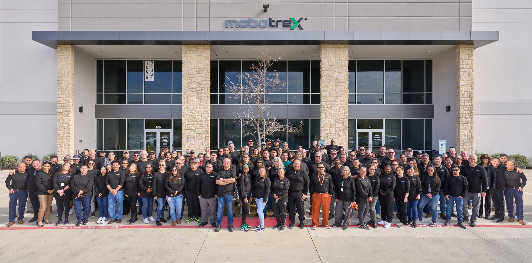 Entire company in black shirts posed outside a Mobotrex office building — Team photography, Austin Entire company in black shirts posed outside a Mobotrex office building