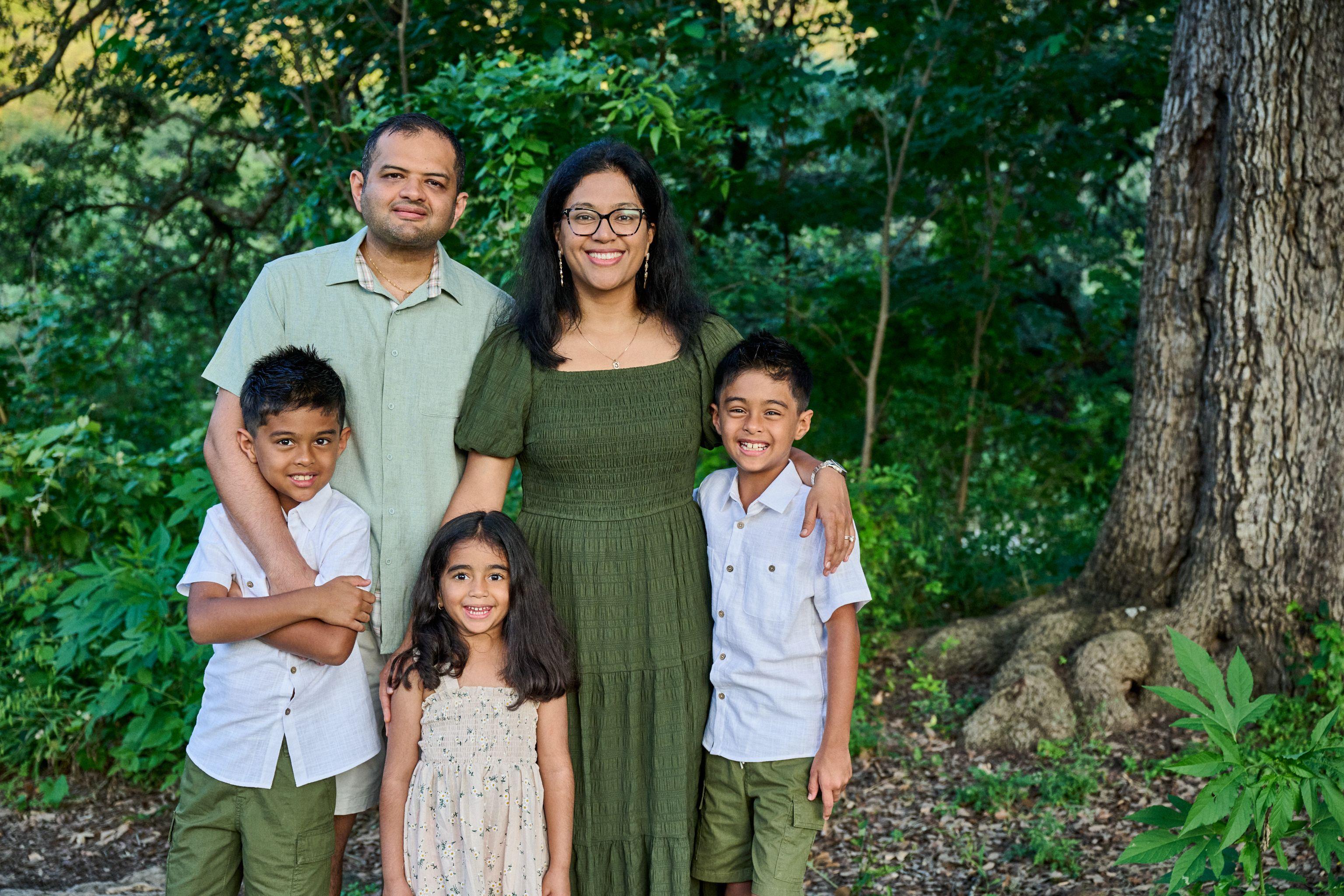 Family of five in green standing together in the woods above Bull Creek — Bull Creek District Park photography, Austin A family of five in green standing together in the woods above Bull Creek