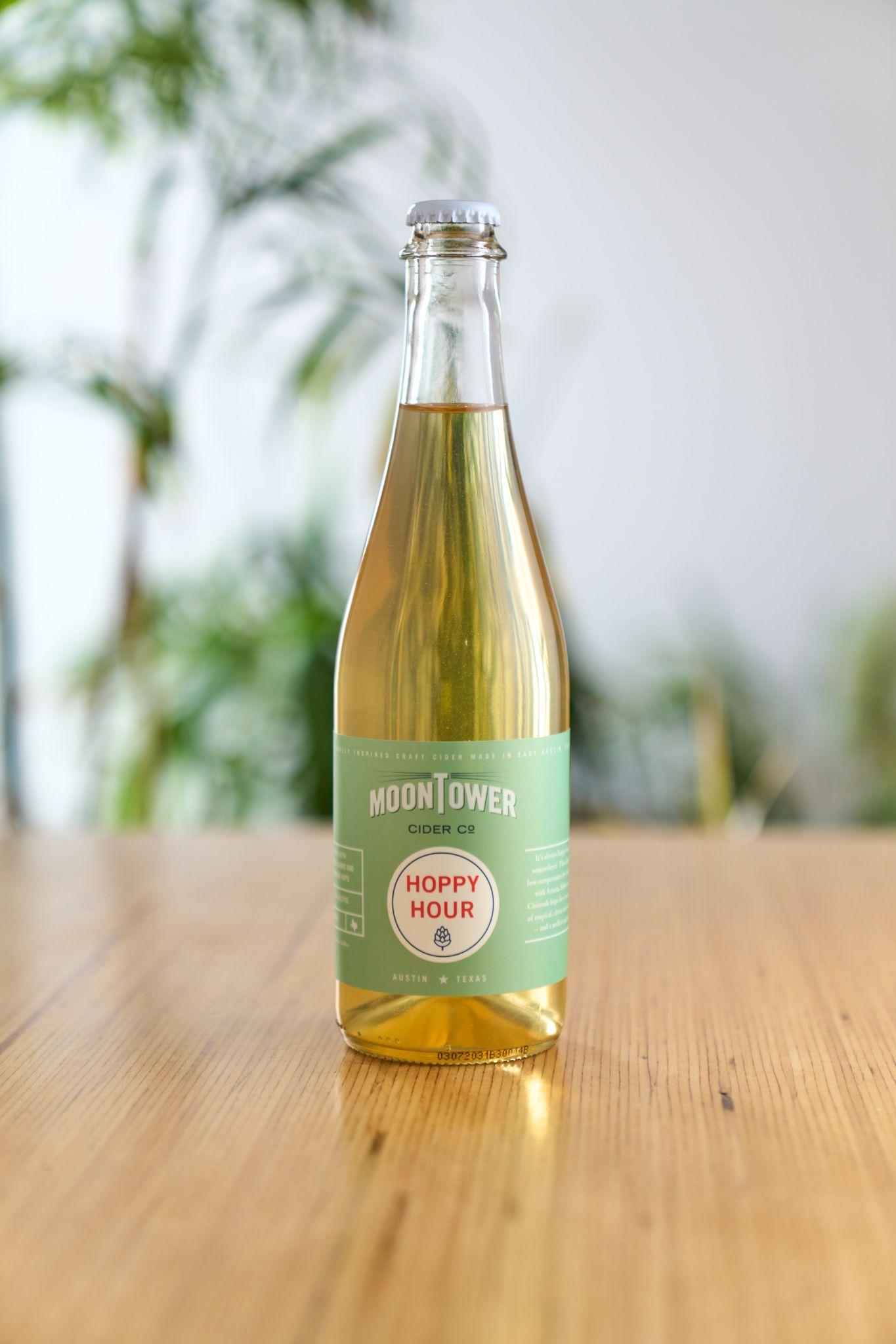 Bottle of Moontower Hoppy Hour cider standing on a wooden table — Product photography, Austin A bottle of Moontower Hoppy Hour cider standing on a wooden table.