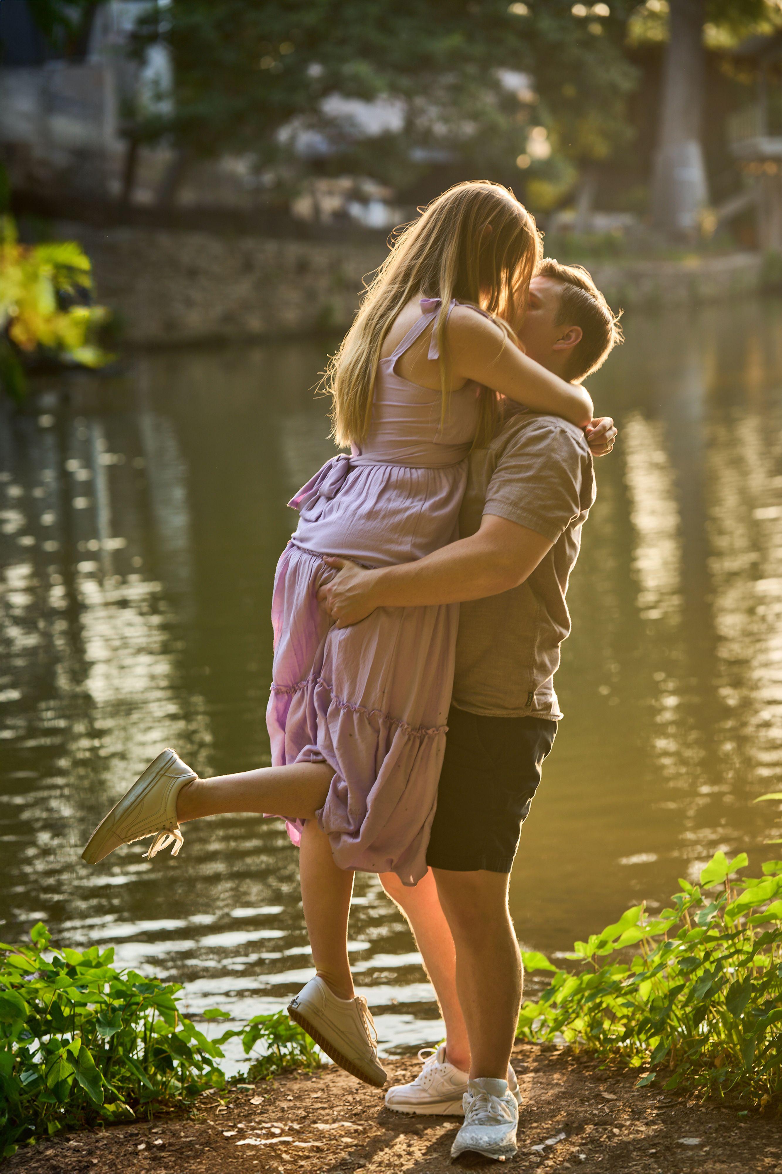 Man lifting a woman in a pink dress off her feet beside the lily pond at Mayfield Park — Mayfield Park photography, Austin A man lifting a woman in a pink dress off her feet beside the lily pond at Mayfield Park