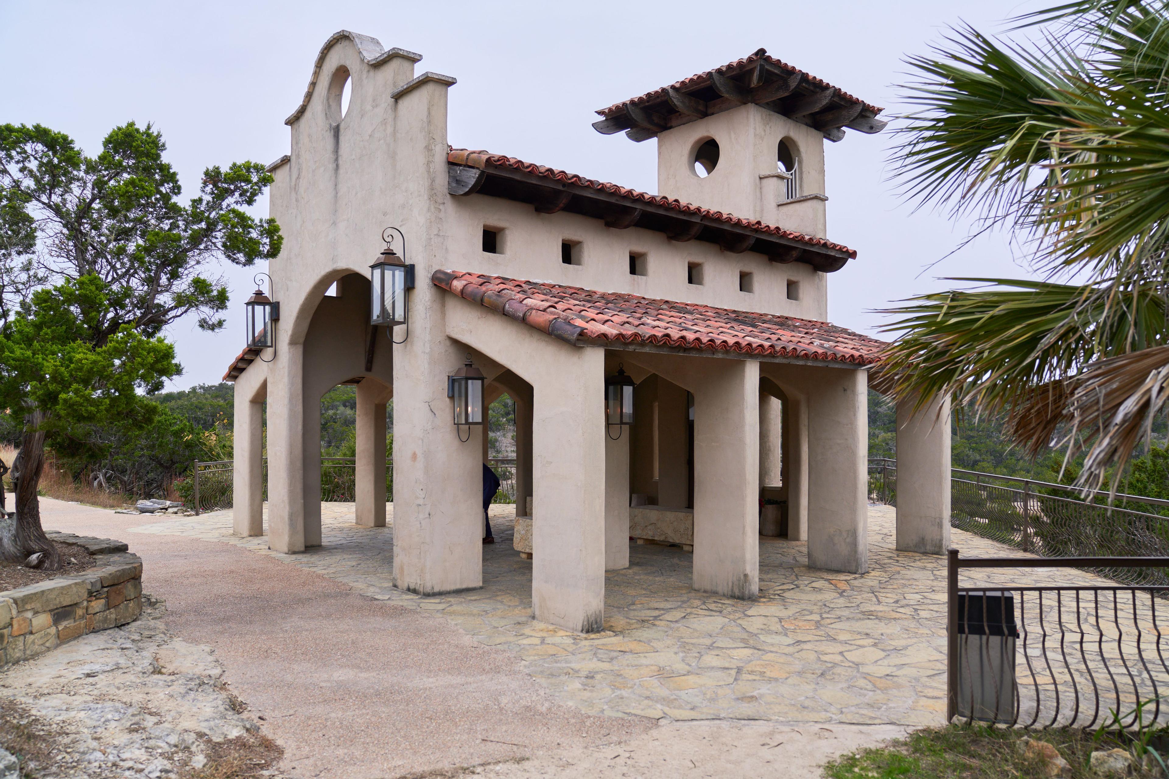 Stucco arcade and red tile roof of Chapel Dulcinea against a clear Hill Country sky — Chapel Dulcinea photography, Austin The stucco arcade and red tile roof of Chapel Dulcinea against a clear Hill Country sky