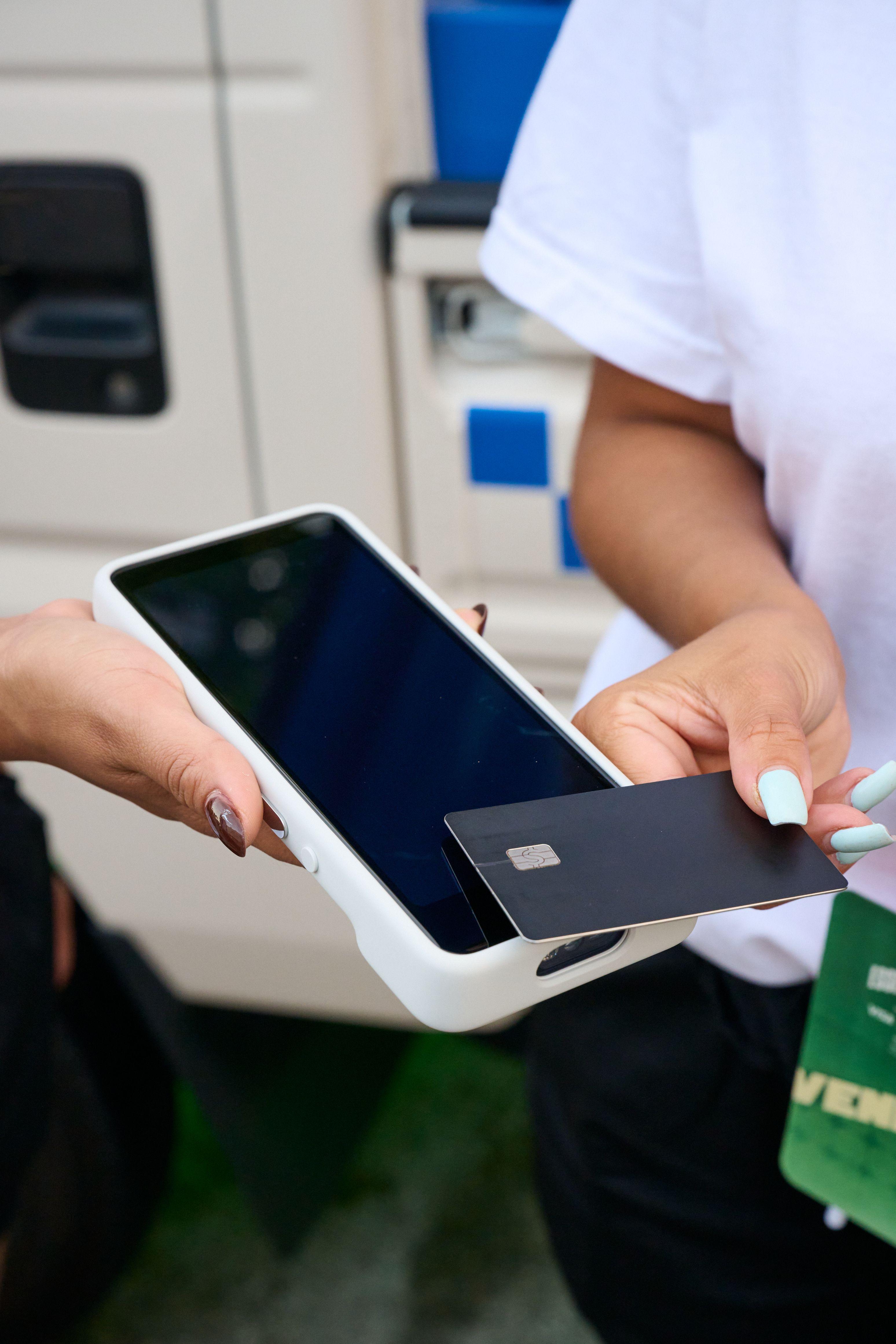 Close view of a bank card being tapped on a handheld payment terminal at an activation — Brand Collaborations photography, Austin A close view of a bank card being tapped on a handheld payment terminal at an activation.