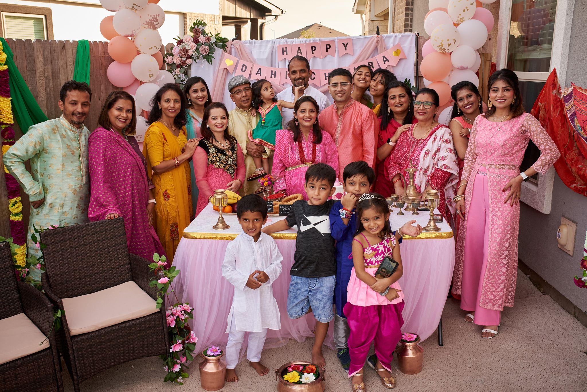 Large family in pink and orange South Asian dress posed together at a birthday party — Family Parties photography, Austin A large family in pink and orange South Asian dress posed together at a birthday party.
