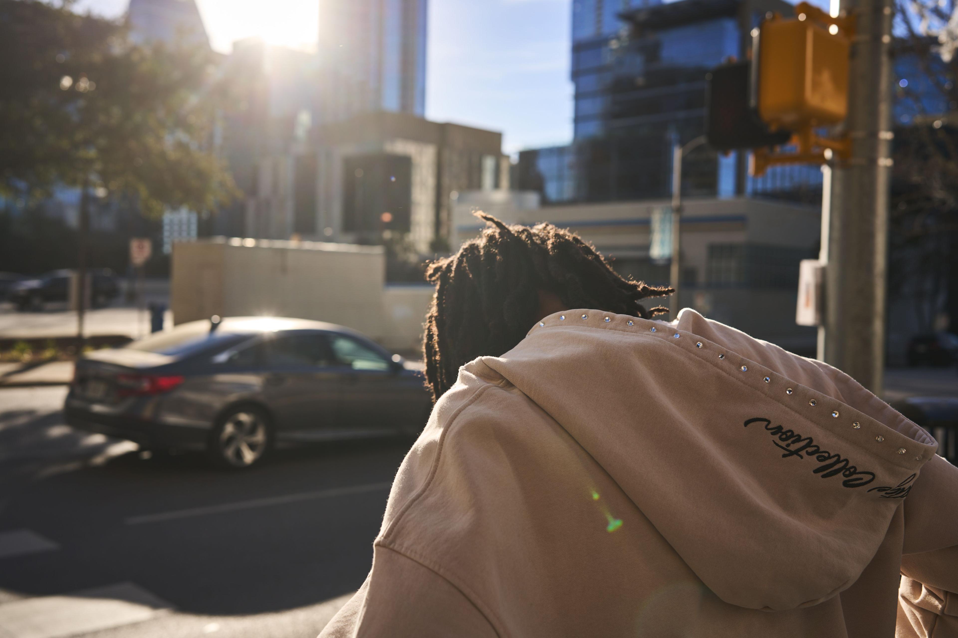 Model photographed from behind on a downtown street, sun flaring over the buildings — Fashion & editorial photography, Austin A model photographed from behind on a downtown street, sun flaring over the buildings.