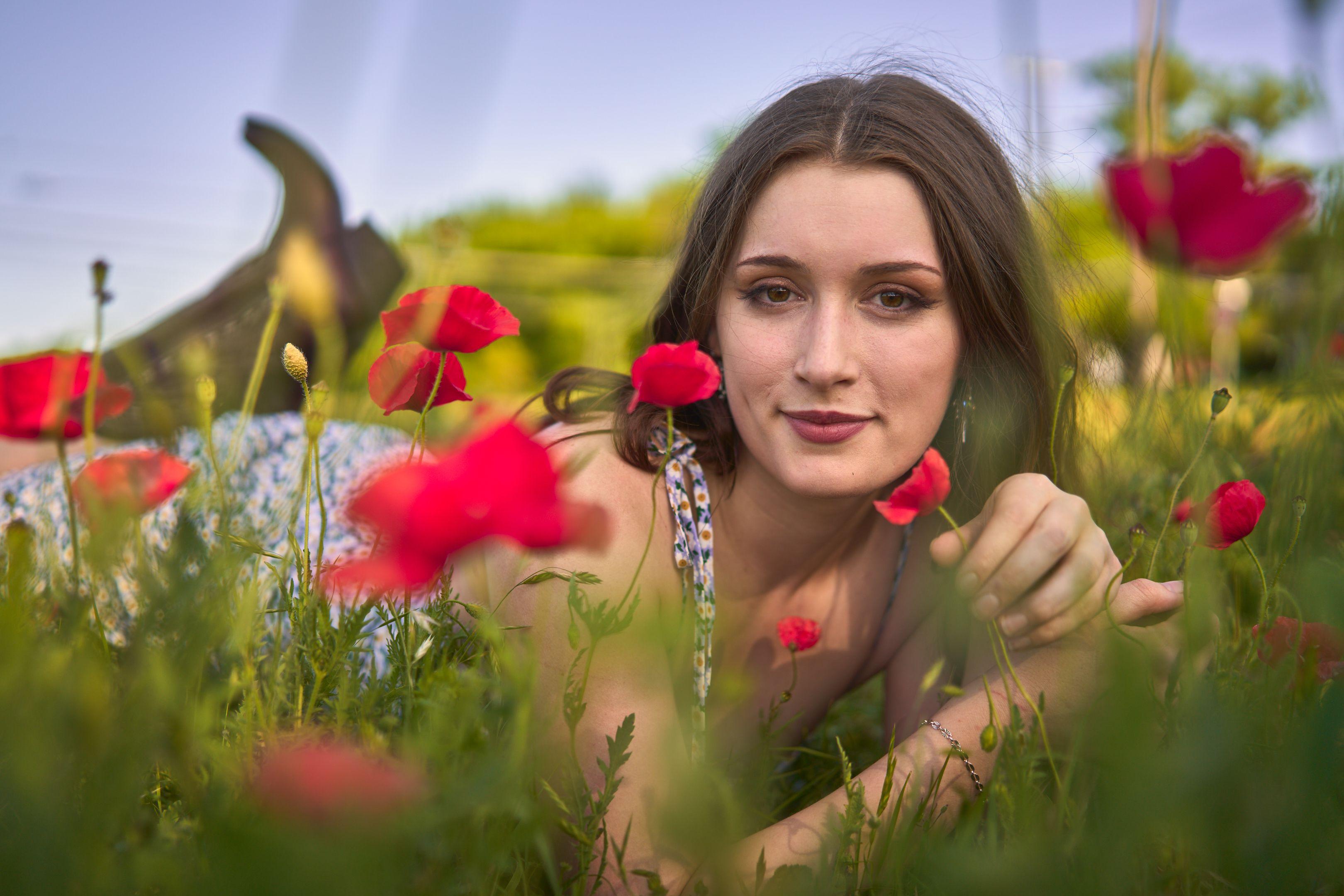 Young woman resting among tall grass and red poppies, looking to camera — Seasonal Wildflower Season in Texas photography, Austin A young woman resting among tall grass and red poppies, looking to camera.
