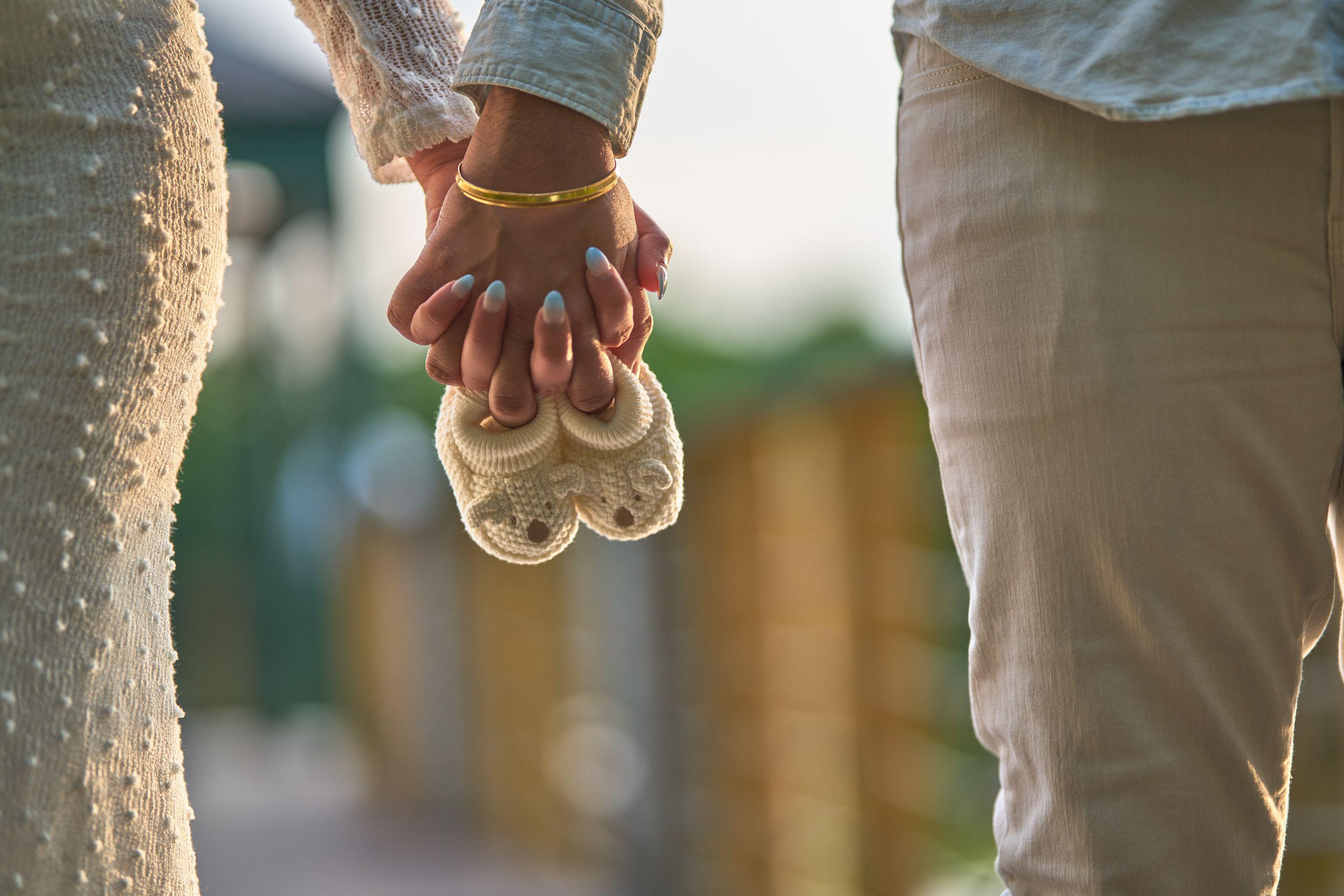 Hands holding crochet baby booties — Maternity photography, Austin Hands holding crochet baby booties