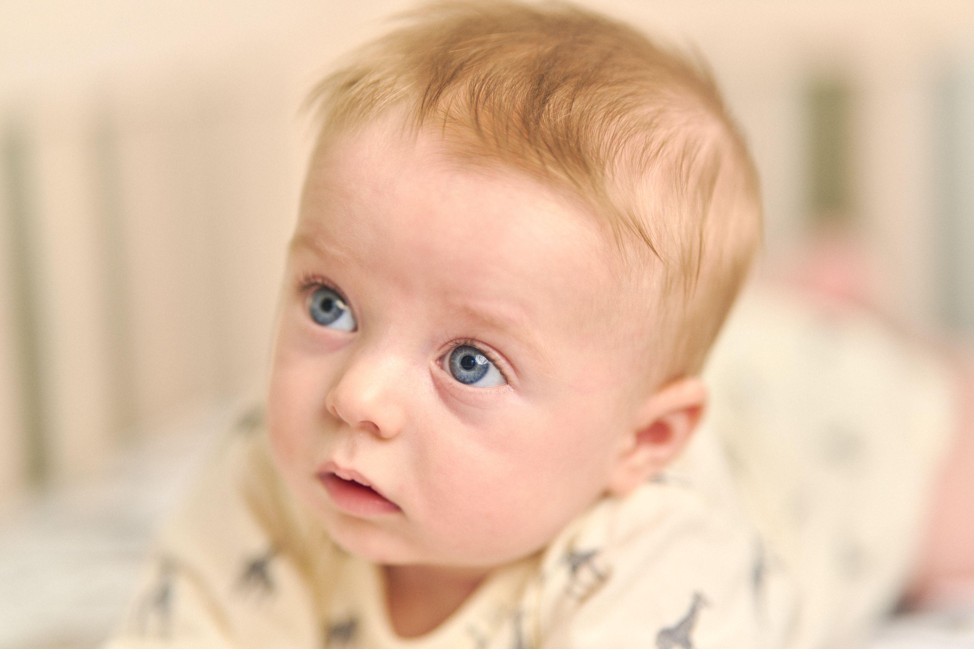 Close portrait of a blue-eyed baby with fine blond hair — Newborn photography, Austin A close portrait of a blue-eyed baby with fine blond hair.