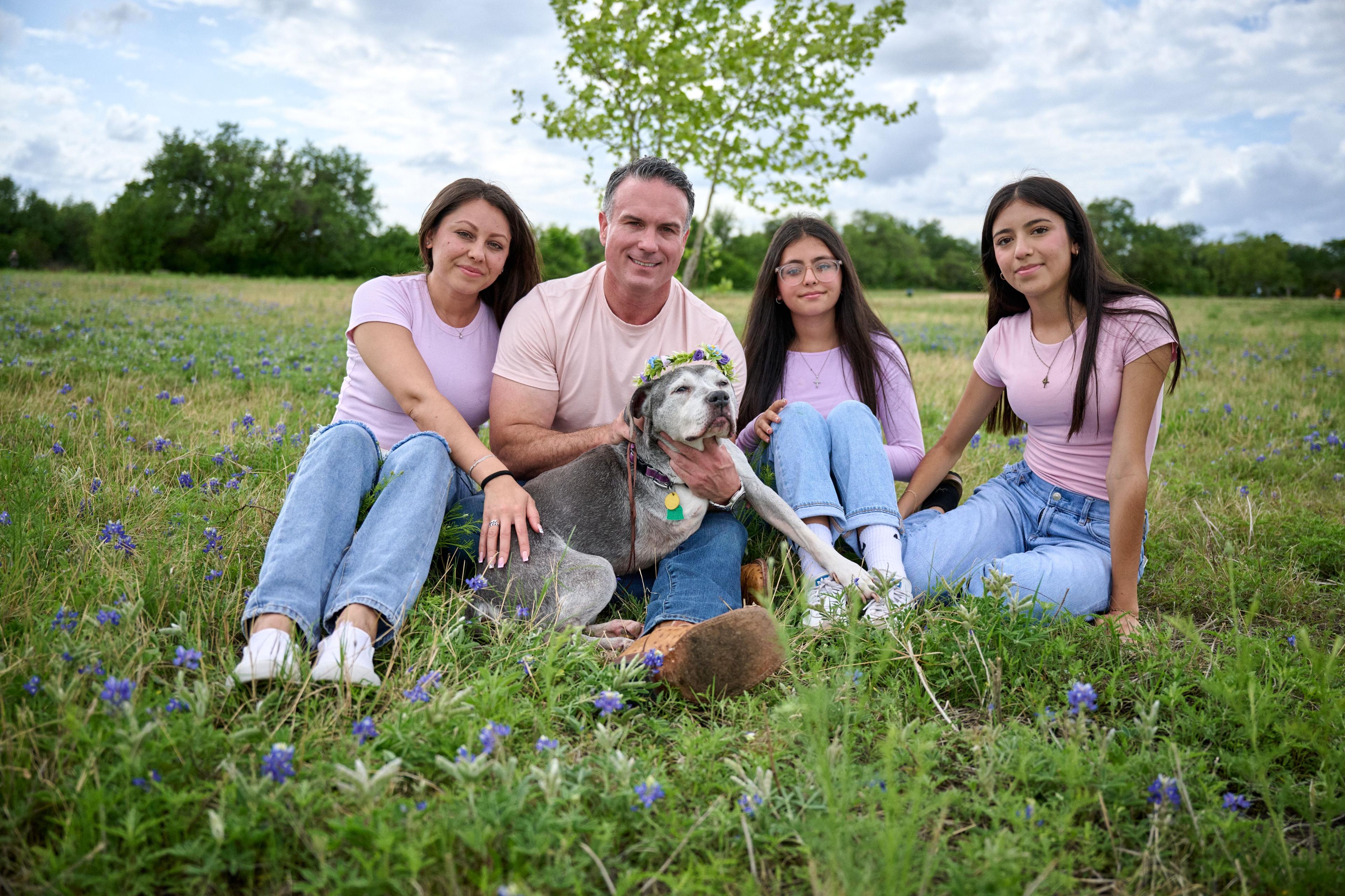 Family seated on the grass in a wildflower meadow with their gray dog — Brushy Creek Lake Park photography, Austin A family seated on the grass in a wildflower meadow with their gray dog.