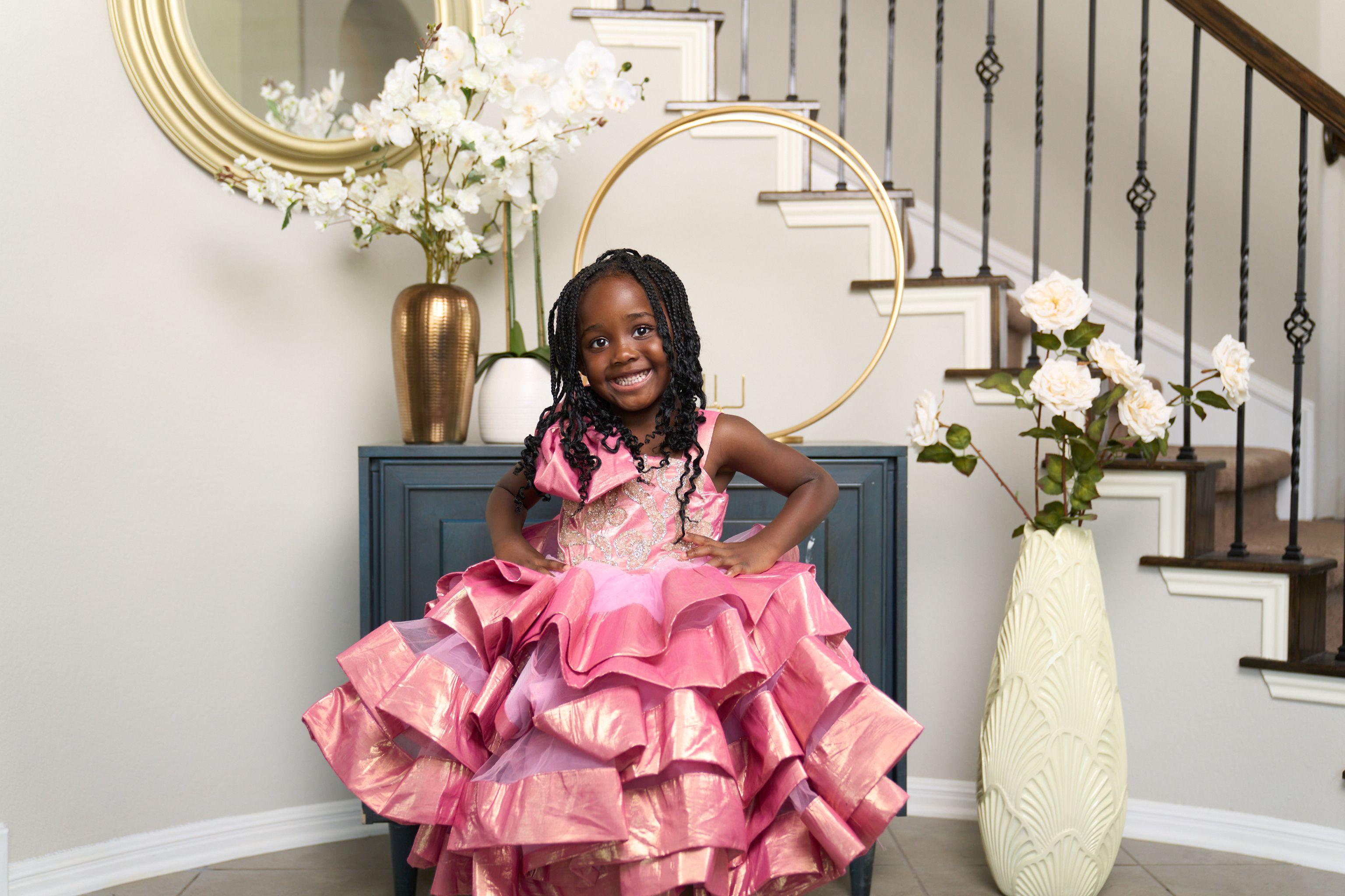 Girl in a layered pink satin gown posing in a decorated hallway — Kids Portraits photography, Austin A girl in a layered pink satin gown posing in a decorated hallway.