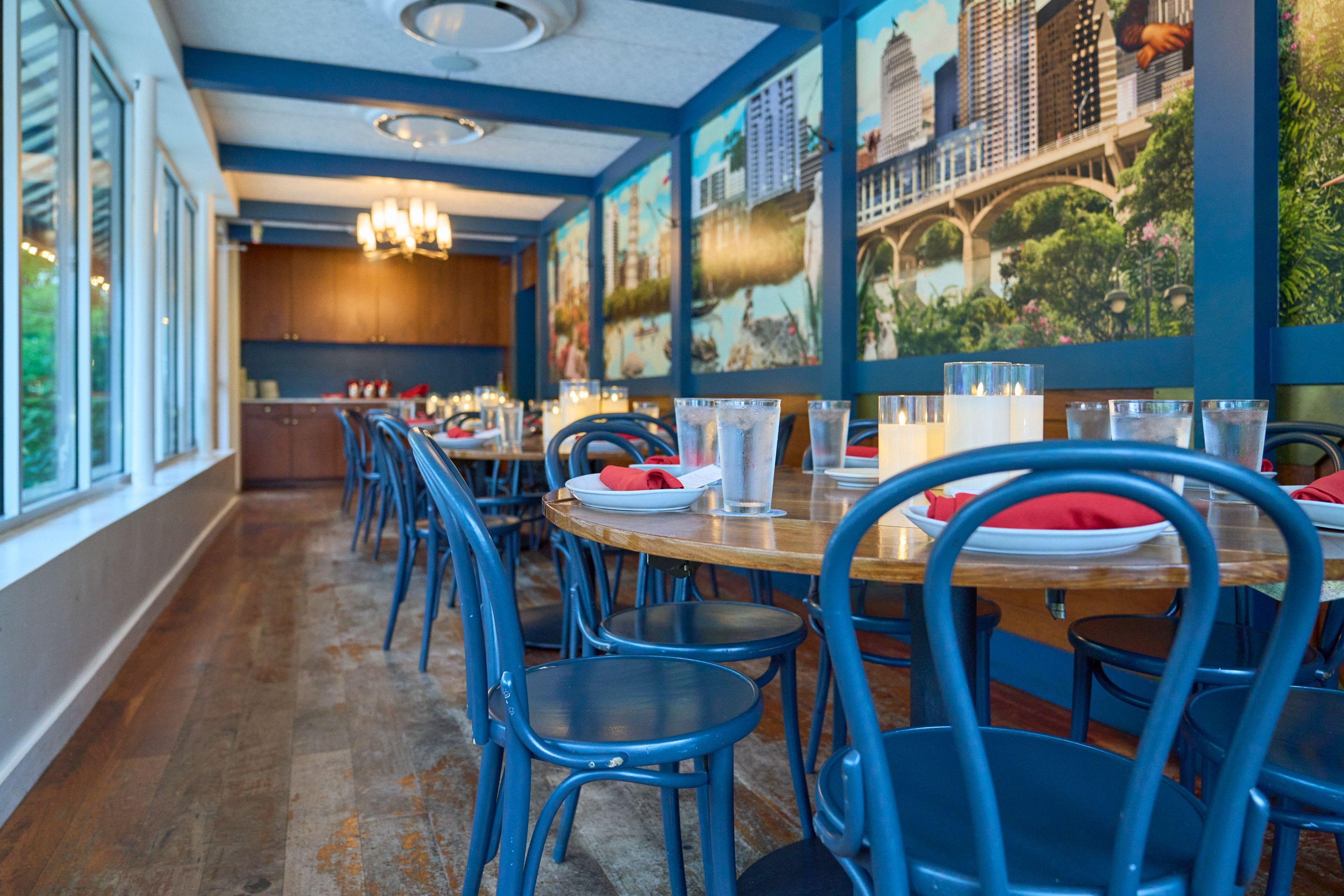 Dining room with blue chairs and Austin skyline murals painted on the walls — Food & restaurant photography, Austin A dining room with blue chairs and Austin skyline murals painted on the walls.