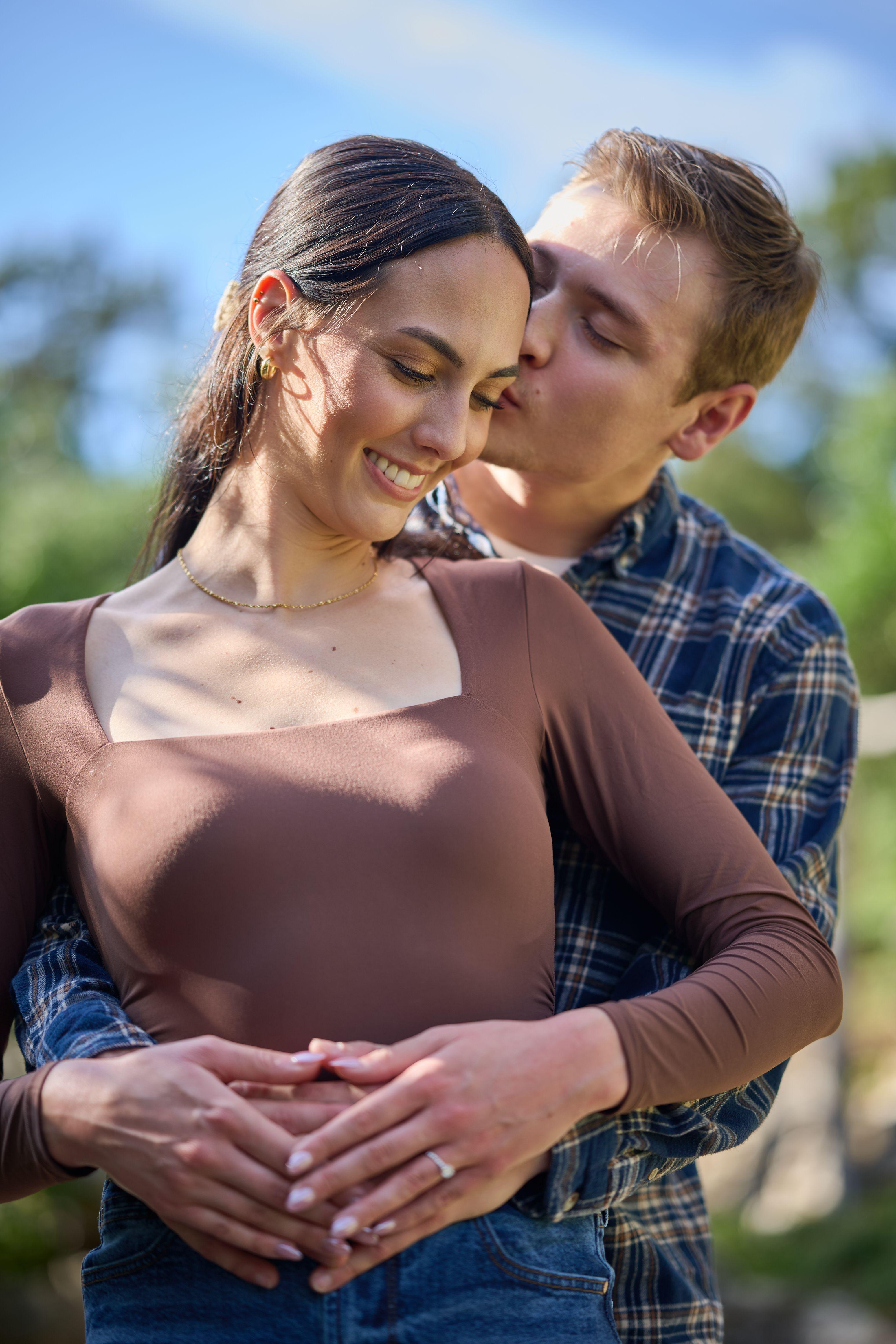 Couple standing close in the garden, his face against her temple, framed by deep green foliage — Zilker Botanical Gardens photography, Austin A couple standing close in the garden, his face against her temple, framed by deep green foliage