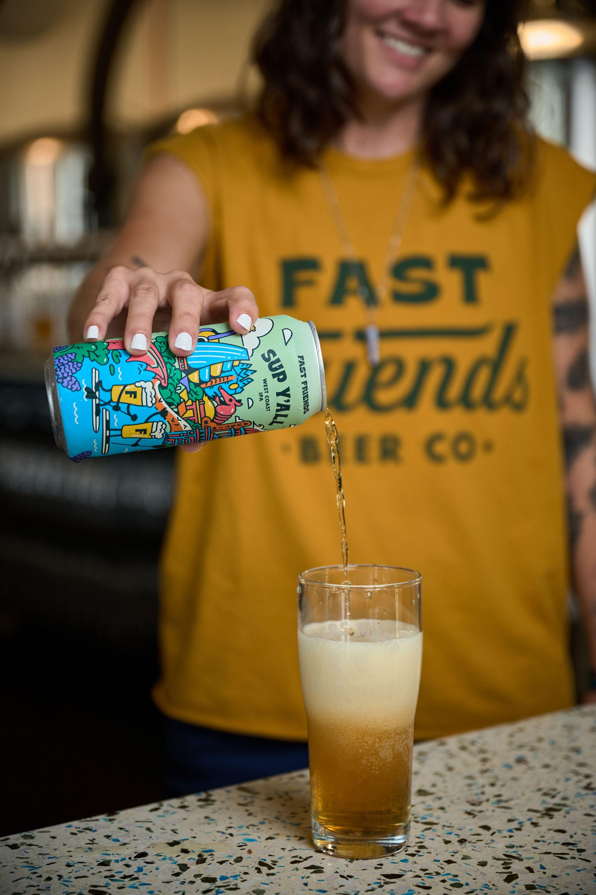 Bartender pouring a can of beer into a glass across the bar — Brand Collaborations photography, Austin A bartender pouring a can of beer into a glass across the bar.
