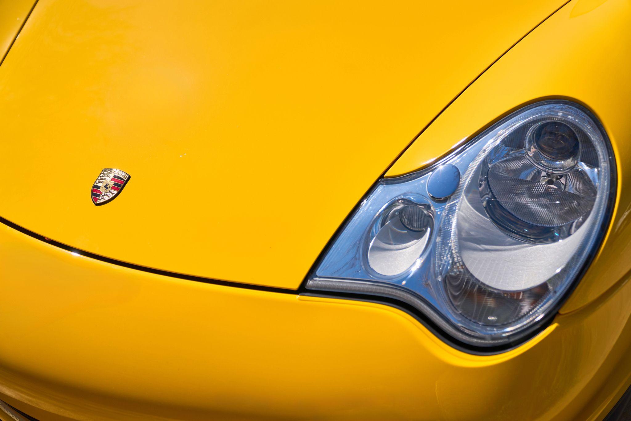 Close detail of a yellow Porsche wing, crest and headlight — Product photography, Austin A close detail of a yellow Porsche wing, crest and headlight.