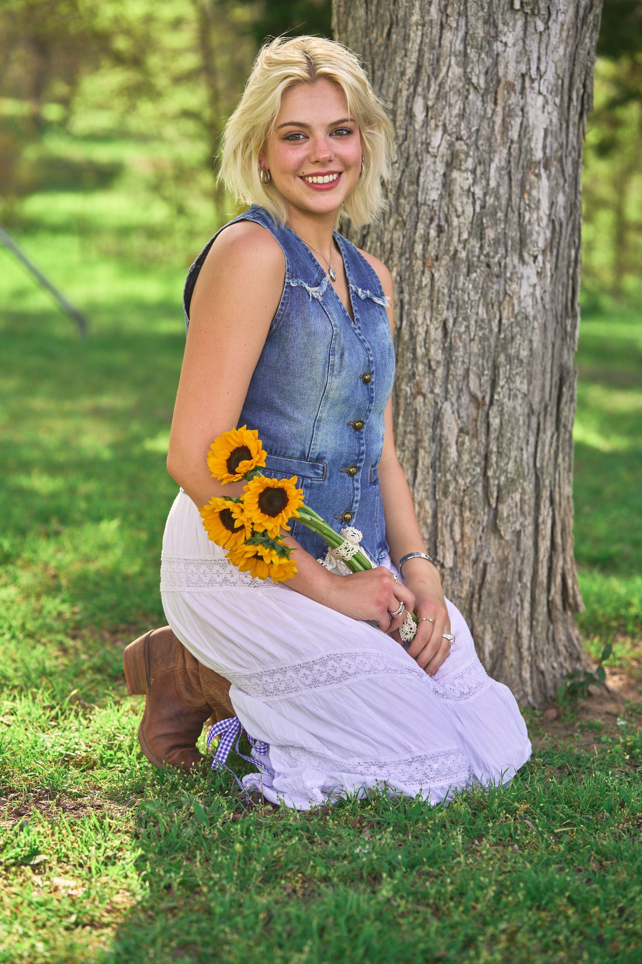 Young woman kneeling in the grass with a bunch of sunflowers at Commons Ford Ranch — Commons Ford Ranch photography, Austin A young woman kneeling in the grass with a bunch of sunflowers at Commons Ford Ranch