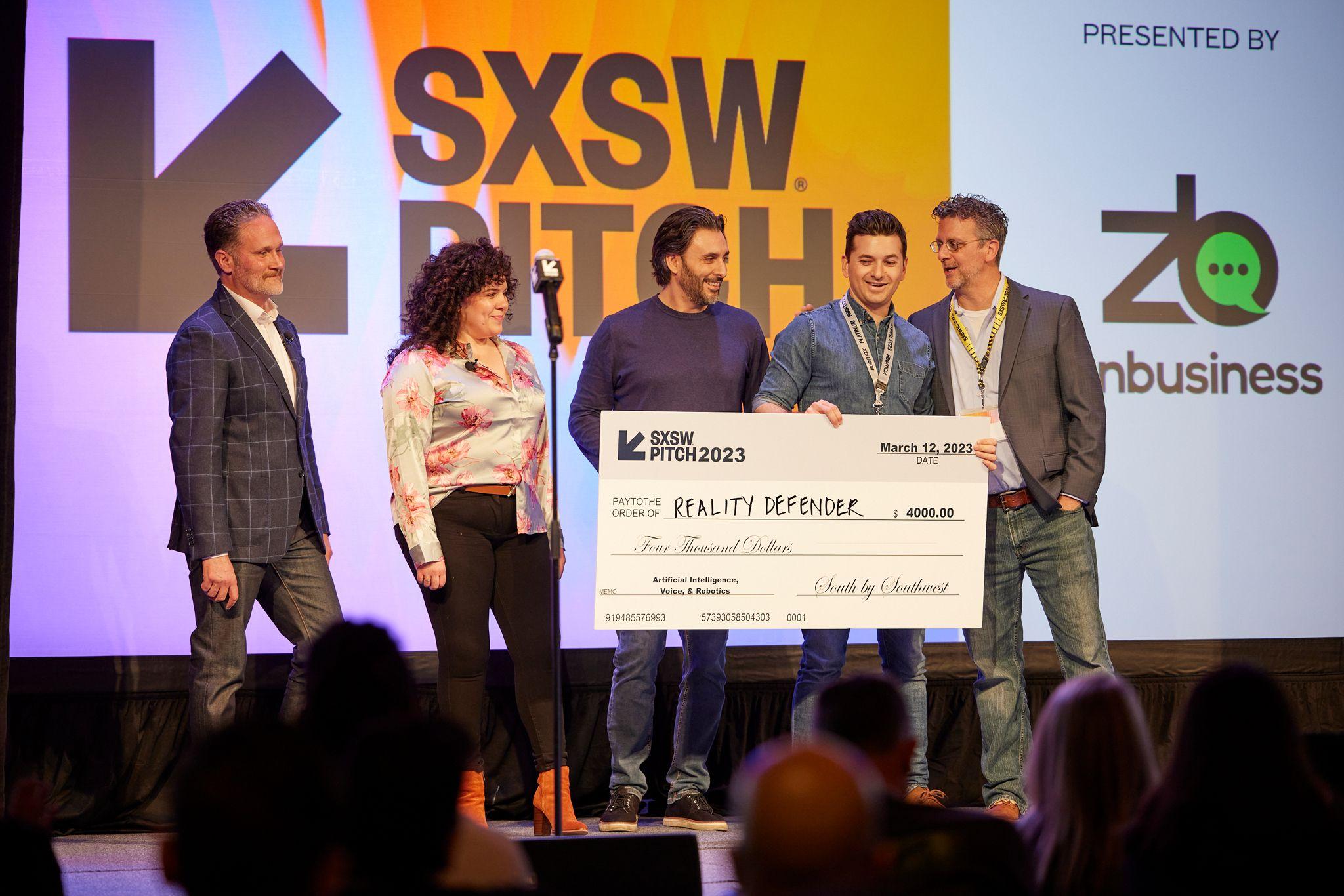 Founders holding an oversized SXSW Pitch 2023 prize check on stage — Conventions & Tradeshows photography, Austin Founders holding an oversized SXSW Pitch 2023 prize check on stage.