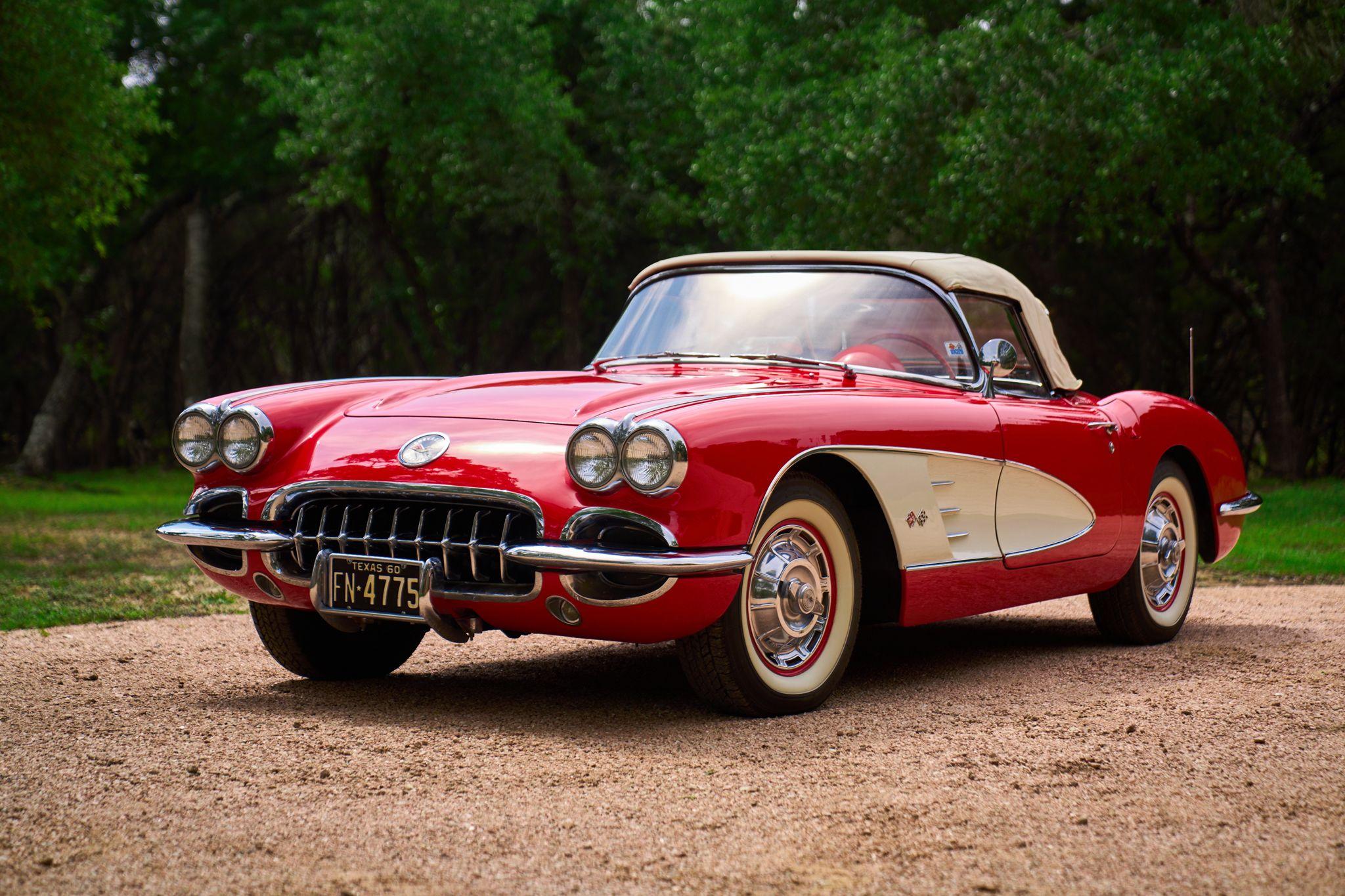 Red 1958 Chevrolet Corvette convertible parked on gravel against green trees — Automotive photography, Austin A red 1958 Chevrolet Corvette convertible parked on gravel against green trees.