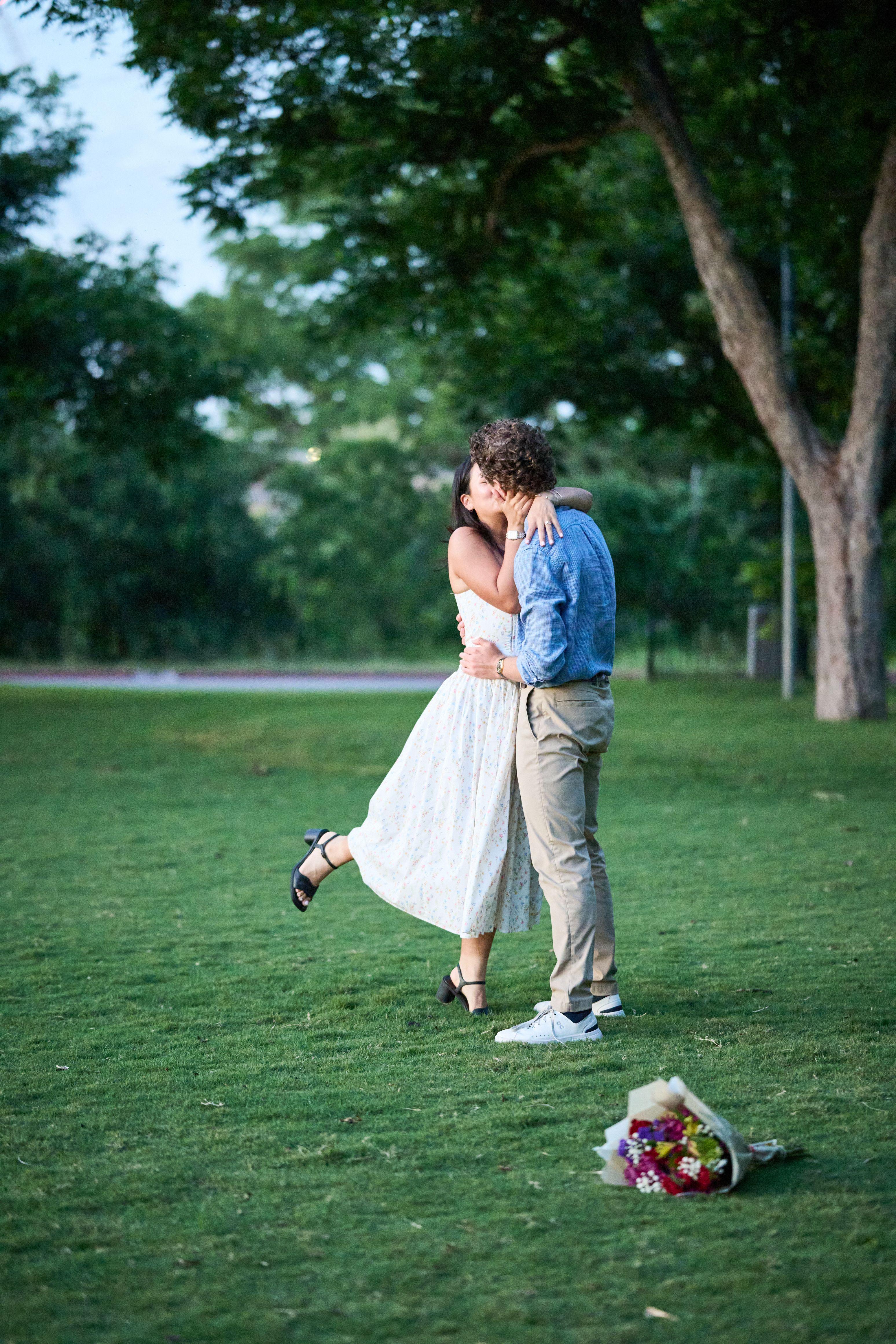 Couple embracing on the Zilker Park lawn with a bouquet lying in the grass where it was dropped — Zilker Park photography, Austin A couple embracing on the Zilker Park lawn with a bouquet lying in the grass where it was dropped