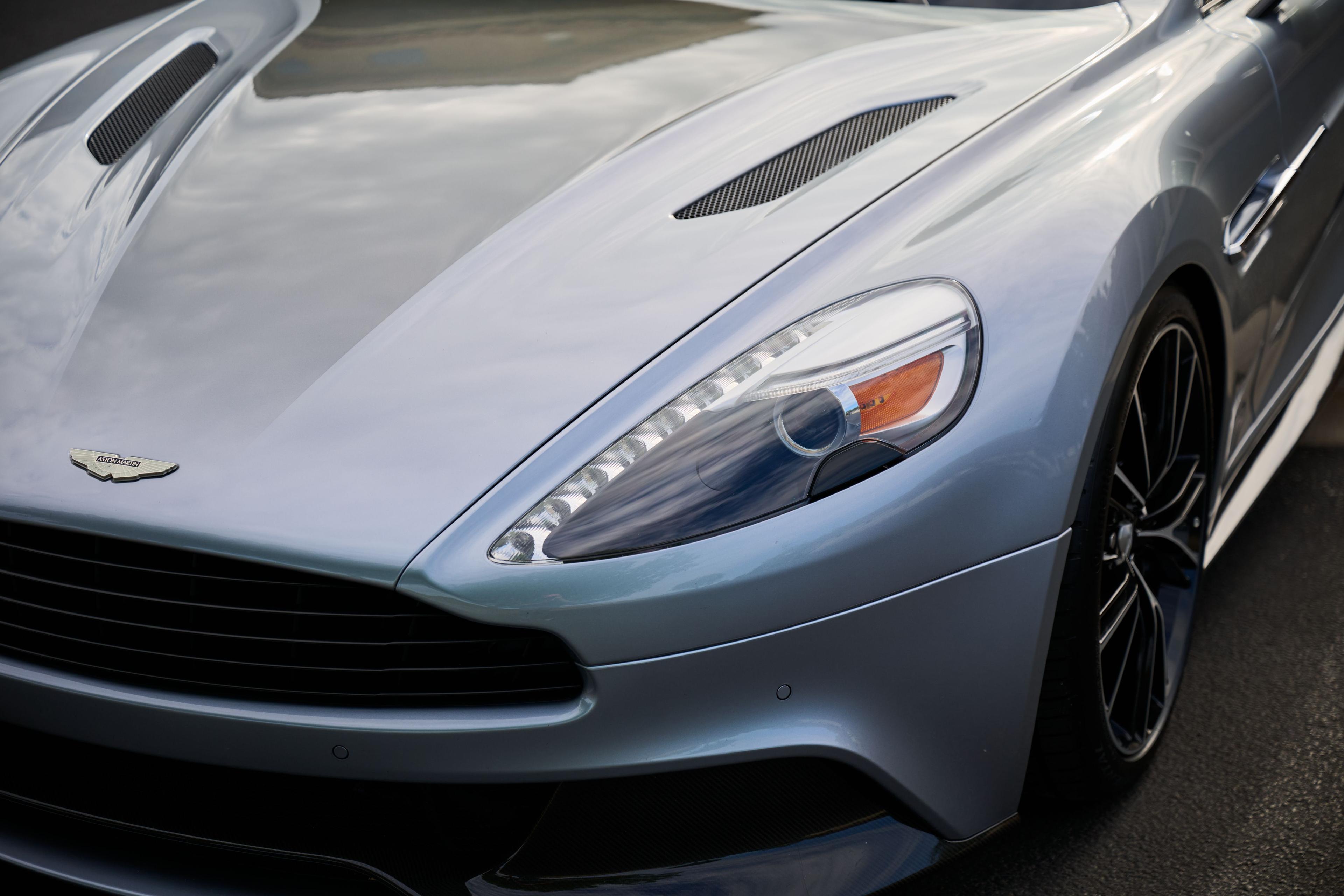 Close detail of the front wing and headlight of a silver Aston Martin — Automotive photography, Austin A close detail of the front wing and headlight of a silver Aston Martin.