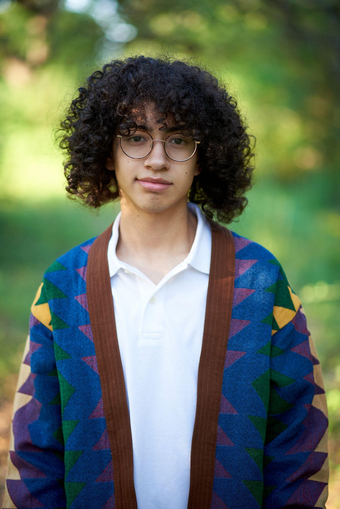 Teenager in a patterned cardigan photographed against green foliage at Circle C Ranch — Circle C Ranch photography, Austin A teenager in a patterned cardigan photographed against green foliage at Circle C Ranch