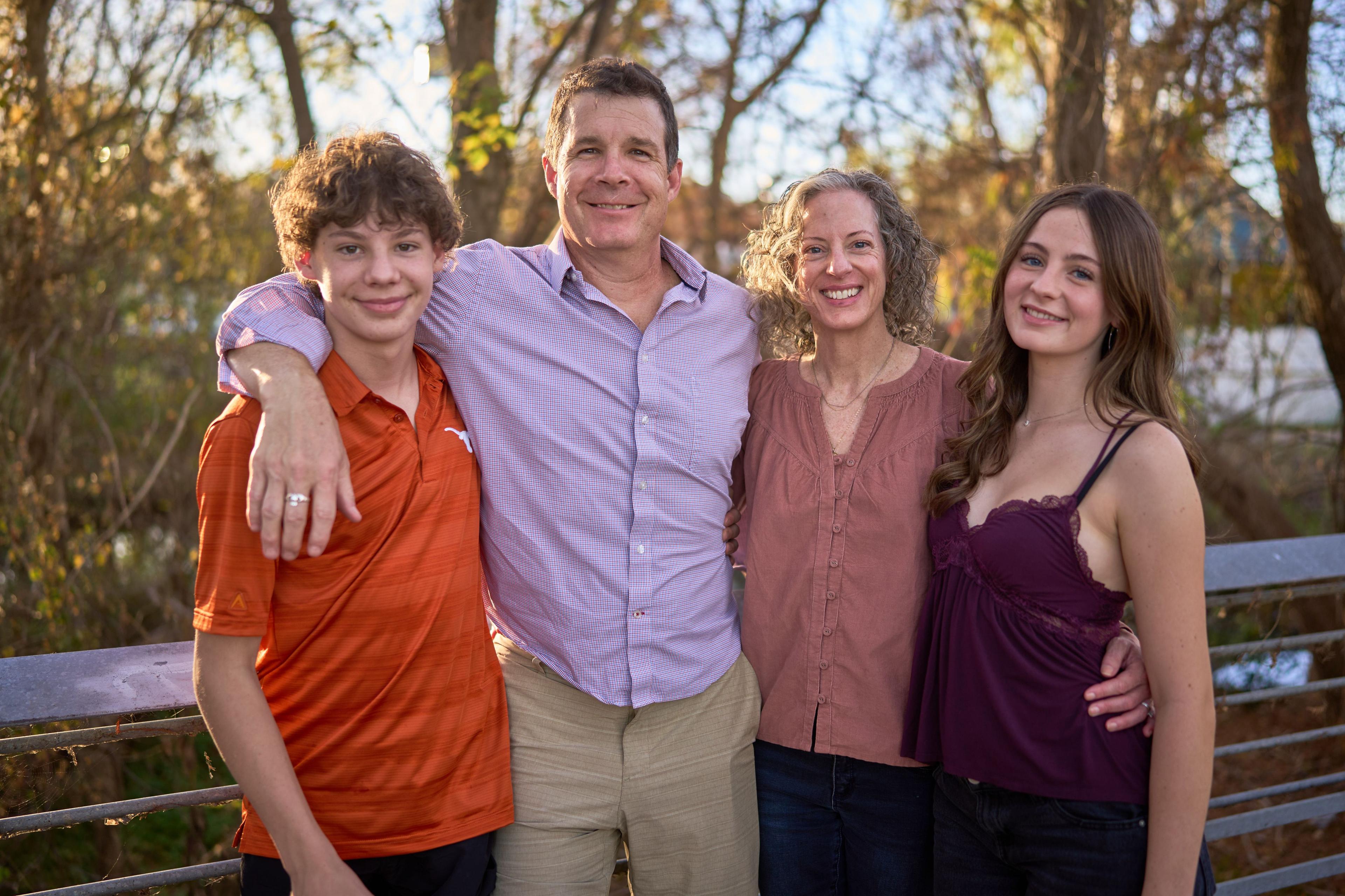Family of five standing arm in arm under autumn trees — Austin Boardwalk photography, Austin A family of five standing arm in arm under autumn trees at the edge of the Lady Bird Lake boardwalk