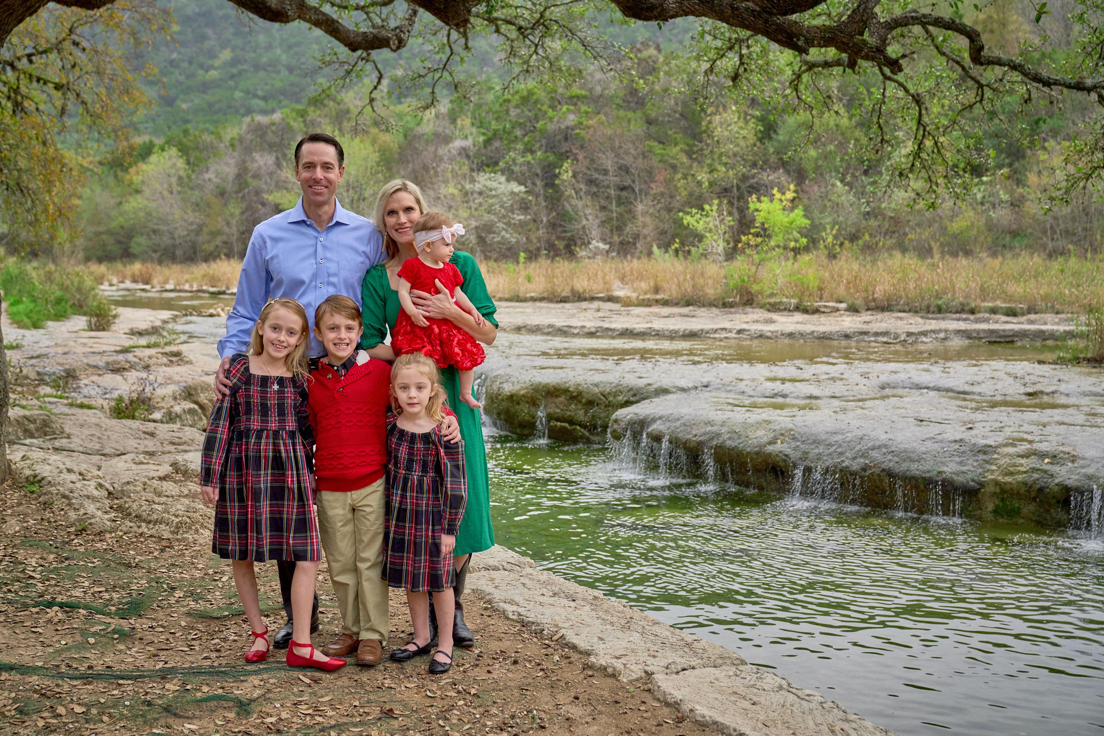 Family of six standing full length on the limestone beside Bull Creek with the low falls — Bull Creek District Park photography, Austin A family of six standing full length on the limestone beside Bull Creek with the low falls behind them