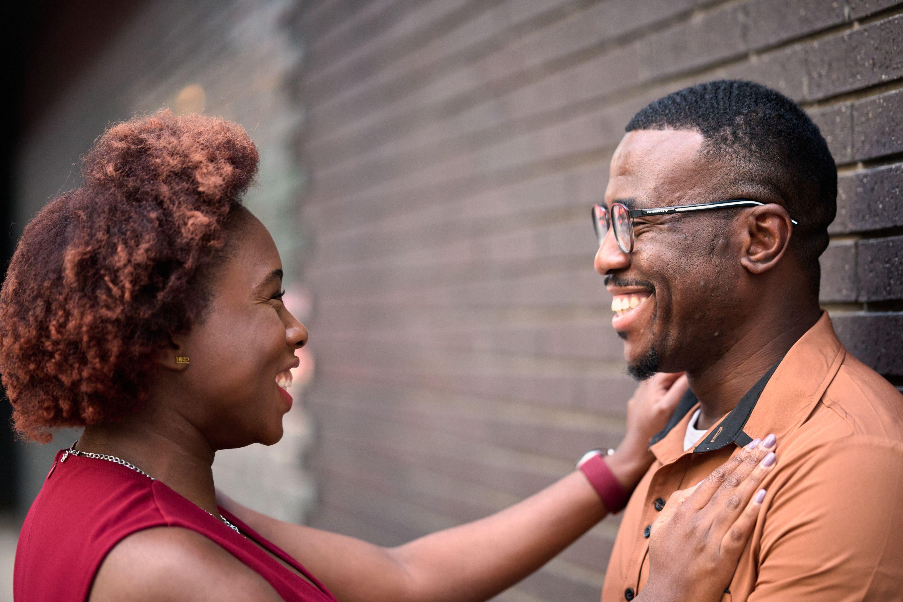 Couple leaning close against a brick wall, she laughing up at him — Congress Avenue photography, Austin A couple leaning close against a brick wall, she laughing up at him.
