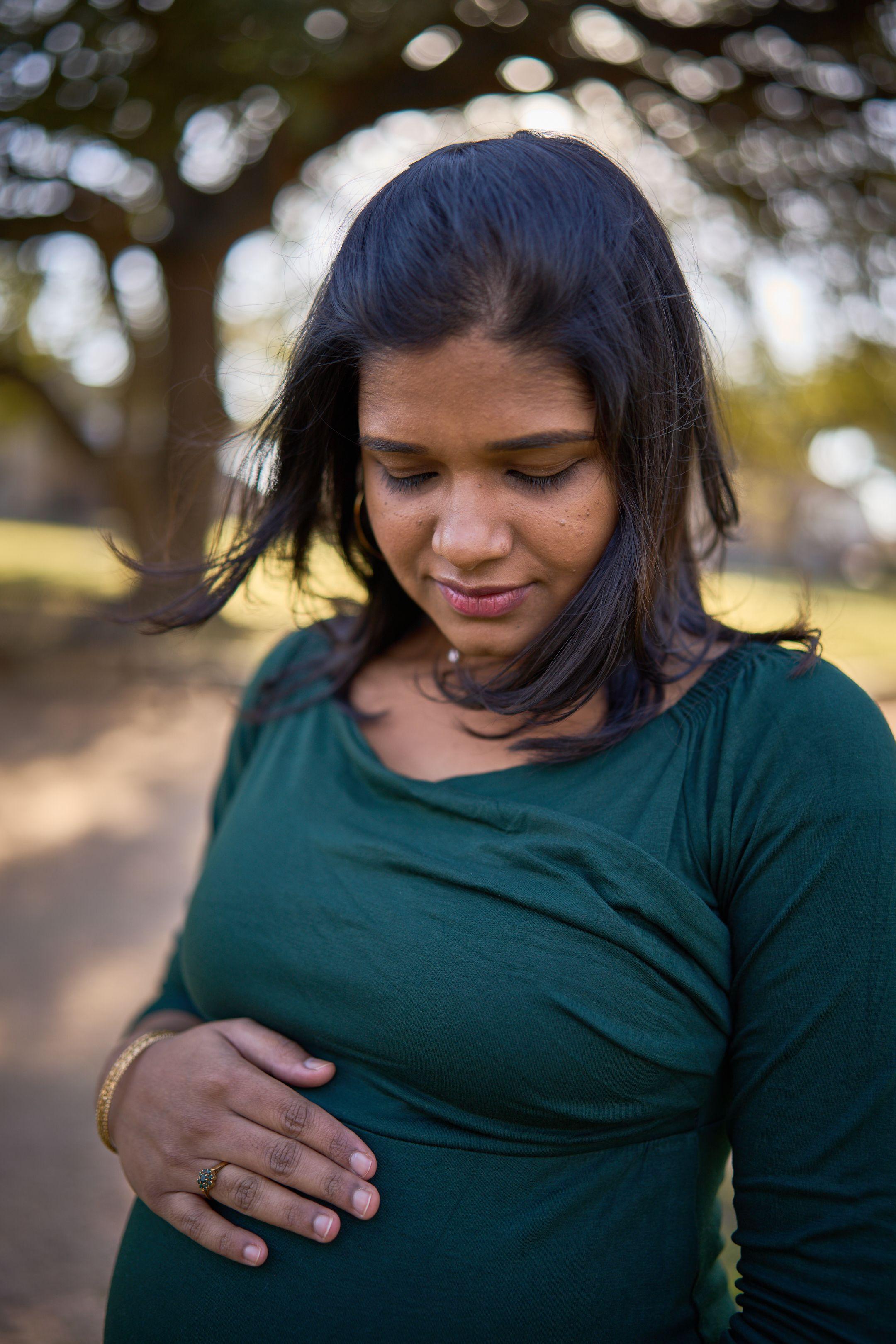 Expectant mother in a green top, hands resting on her belly — Maternity photography, Austin Expectant mother in a green top, hands resting on her belly