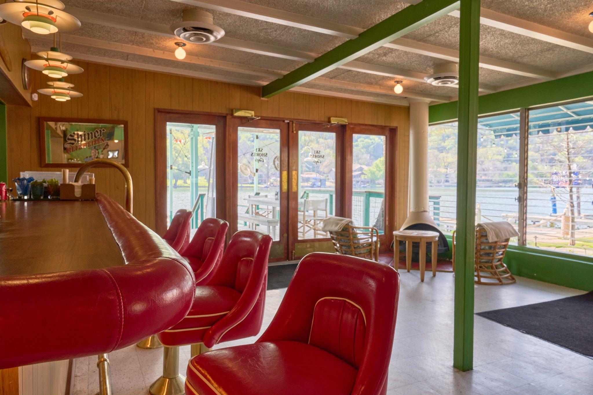 Red vinyl booths and windows in a retro diner dining room — Food & restaurant photography, Austin Red vinyl booths and windows in a retro diner dining room.