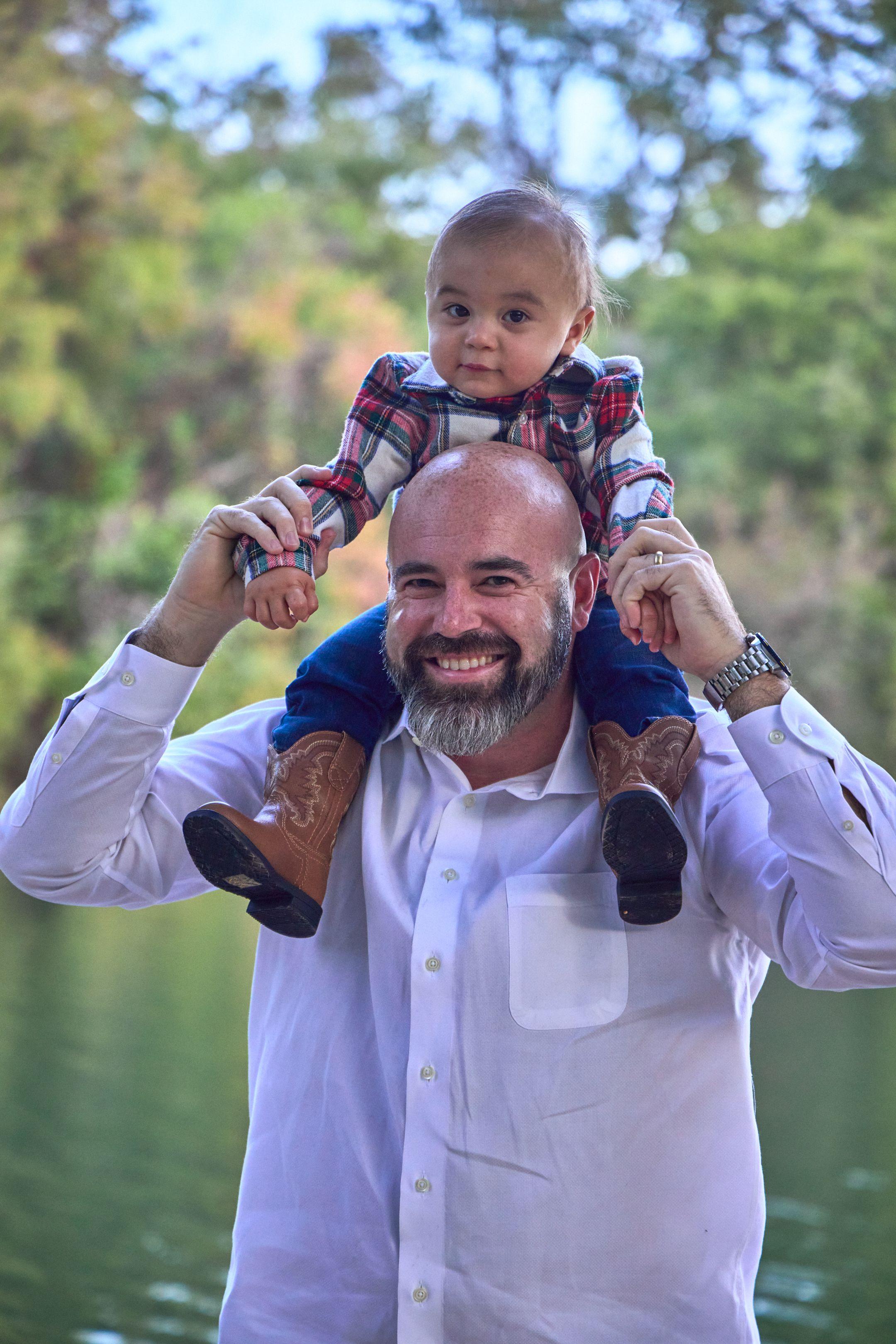 Father carrying his baby on his shoulders at Red Bud Isle, green water — Red Bud Isle photography, Austin A father carrying his baby on his shoulders at Red Bud Isle, green water behind