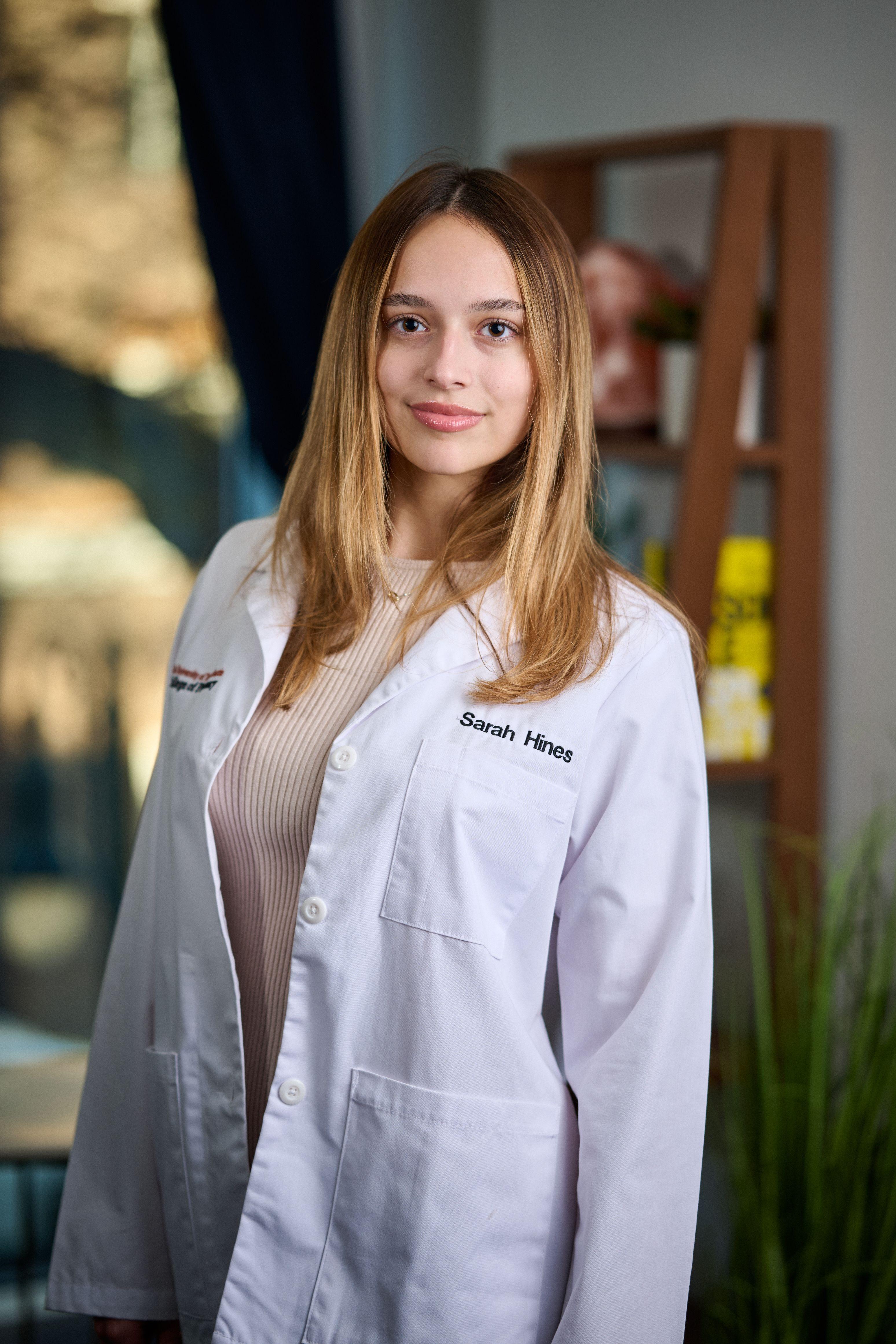 Pharmacy student in a white lab coat with her name embroidered on it, photographed — Business headshots, Austin A pharmacy student in a white lab coat with her name embroidered on it, photographed in a bright building interior