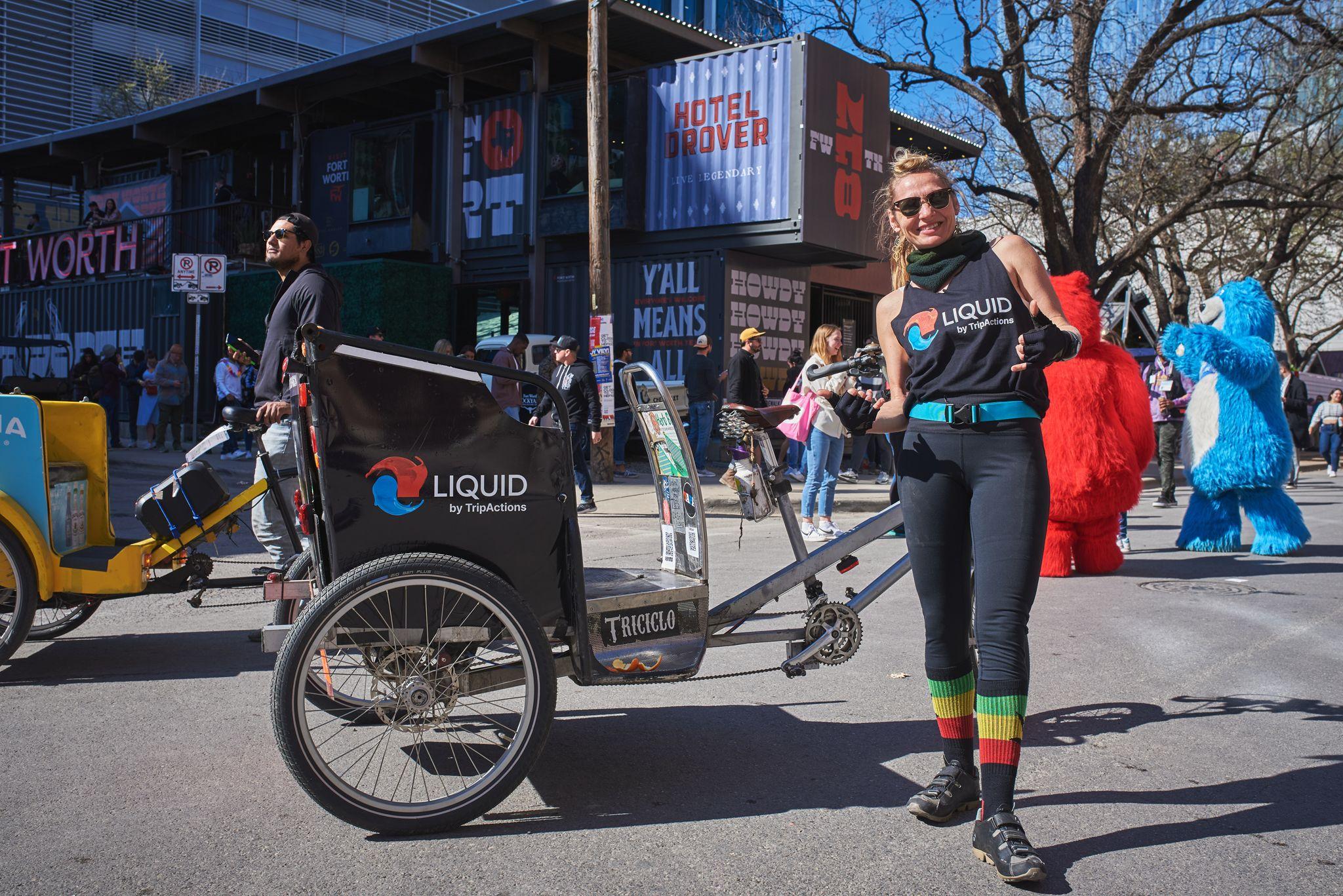 Brand staffer in Liquid Death gear standing beside a branded pedicab — Downtown Austin photography, Austin A brand staffer in Liquid Death gear standing beside a branded pedicab at a busy street activation.