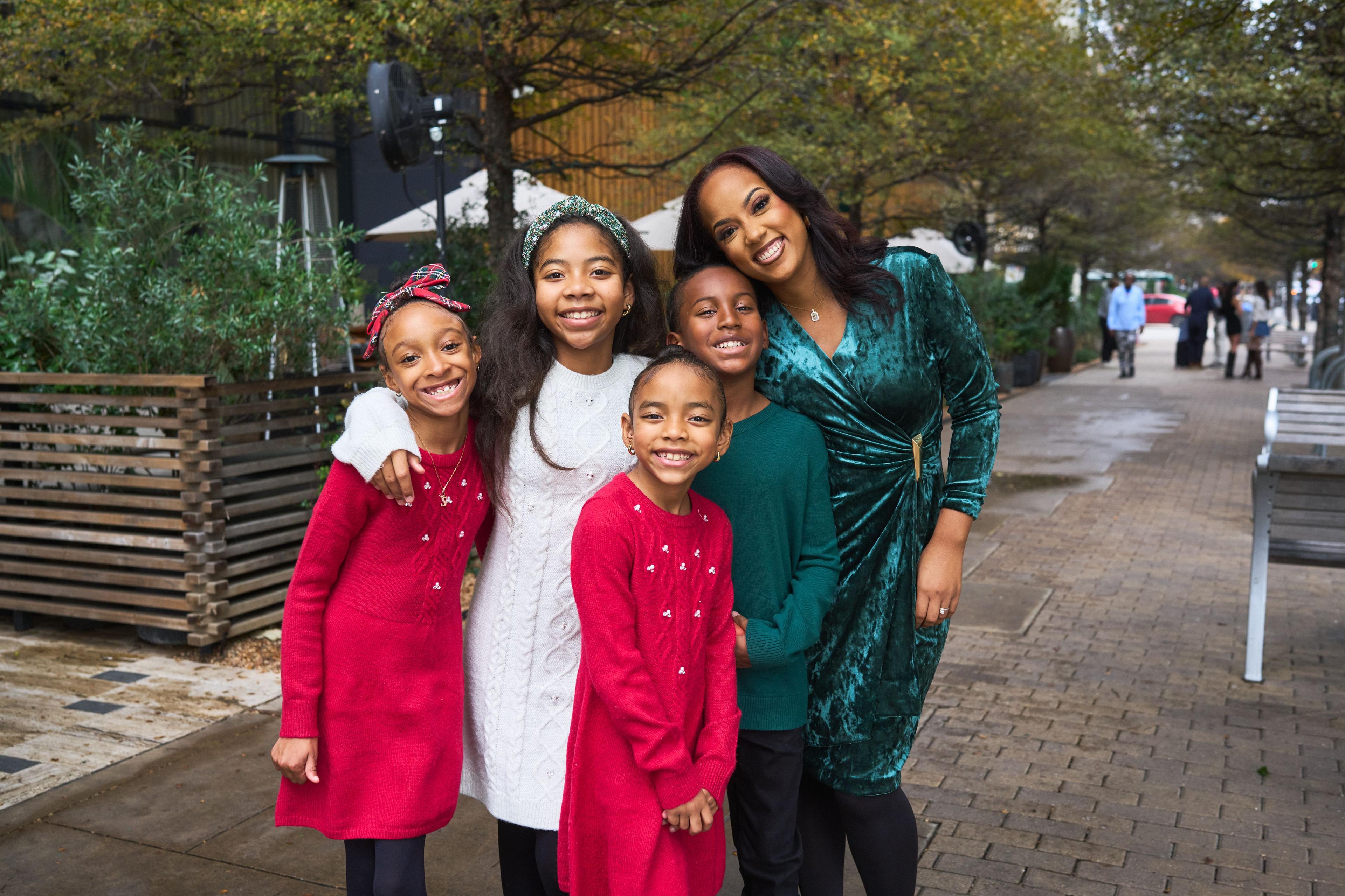 Family in red, white and green posed on a downtown pavement under bare trees — Downtown Austin photography, Austin A family in red, white and green posed on a downtown pavement under bare trees.