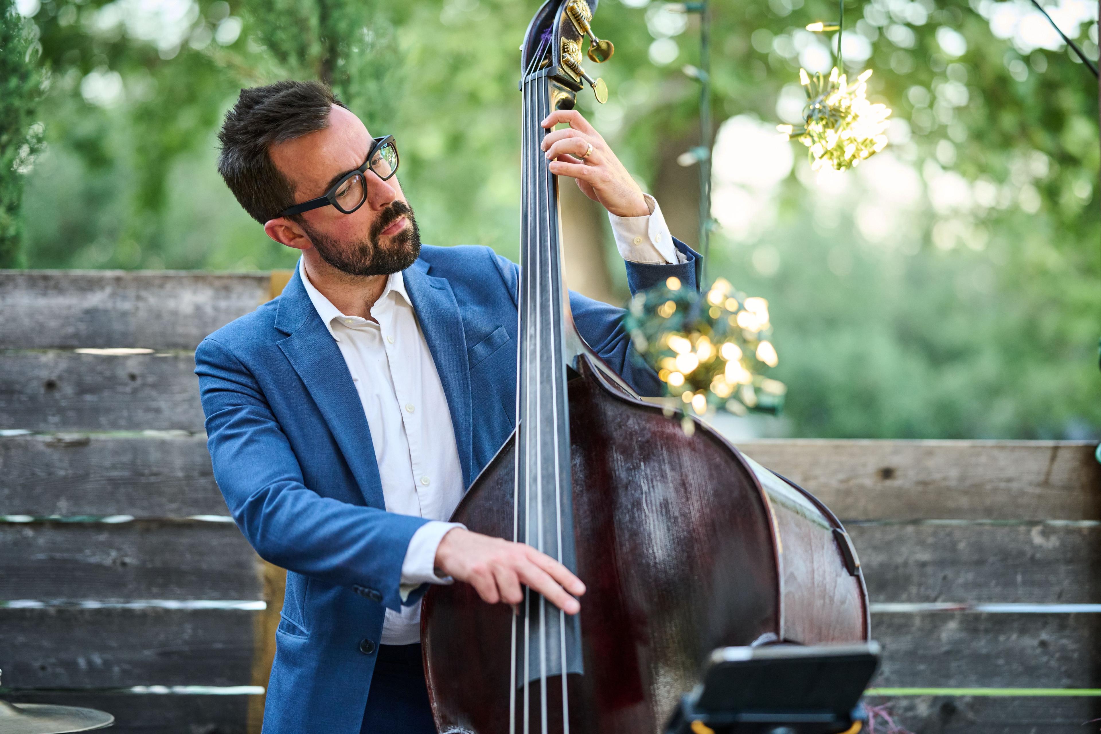 Double bass player in a blue jacket performing outdoors — Formal Celebrations photography, Austin A double bass player in a blue jacket performing outdoors.
