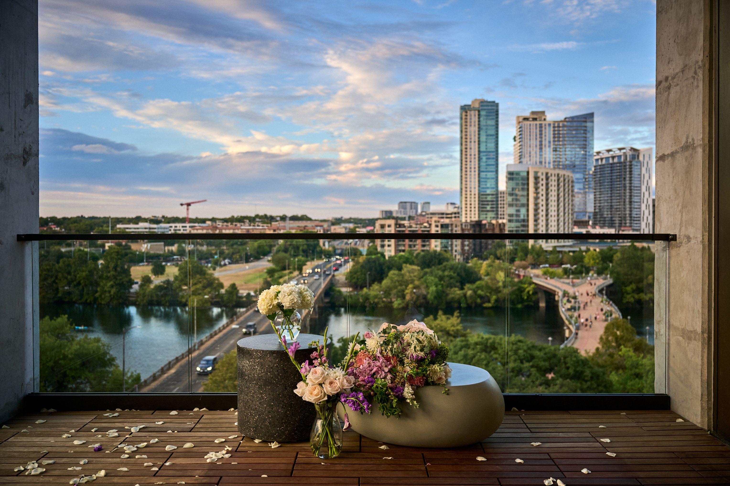 Rooftop terrace with flower arrangements overlooking Lady Bird Lake — Hospitality & leisure photography, Austin A rooftop terrace with flower arrangements overlooking Lady Bird Lake and the downtown Austin skyline at dusk.