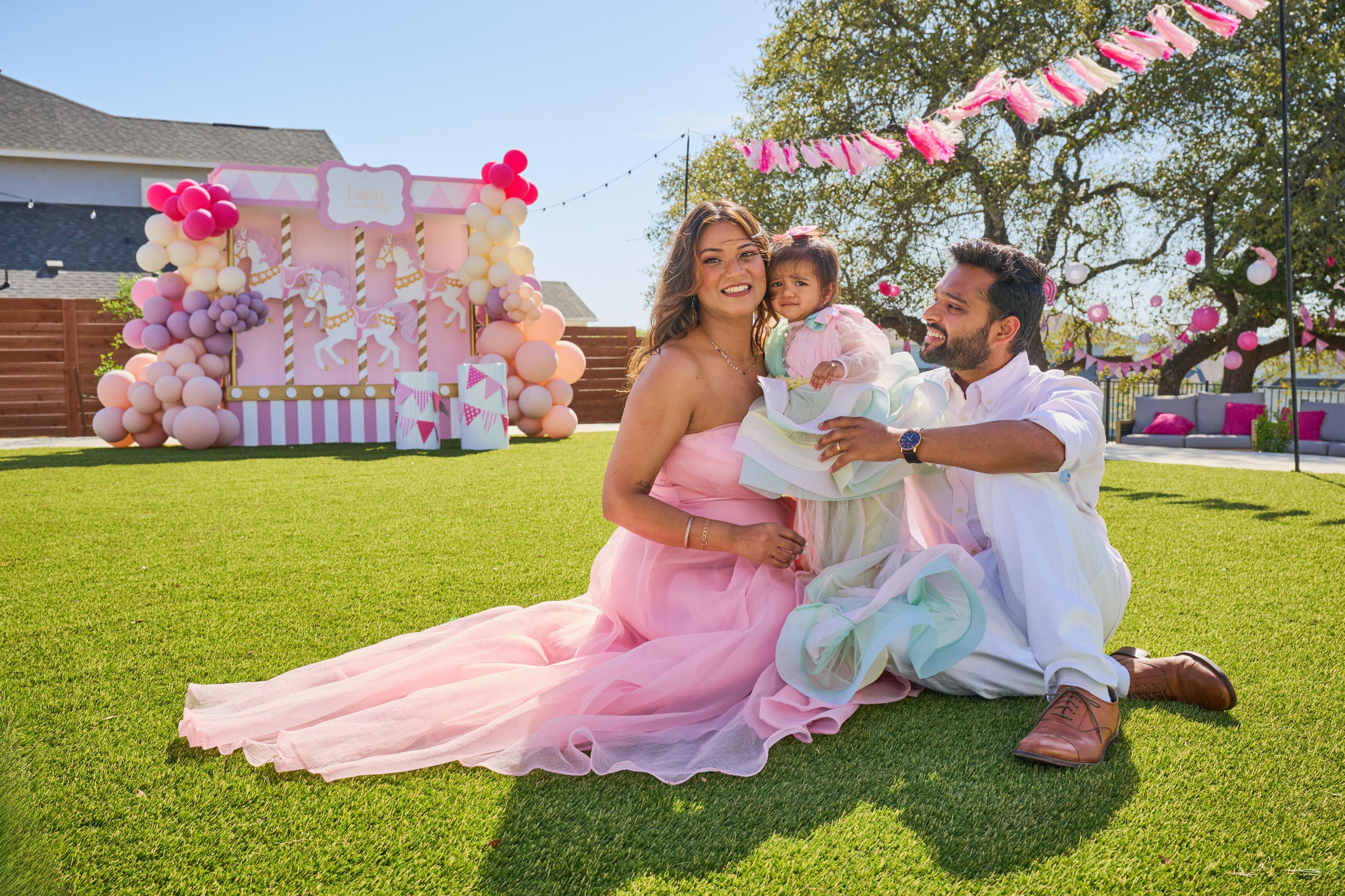 Mother in a pastel tulle gown seated on the grass with her toddler and husband — Family Parties photography, Austin Family Parties
