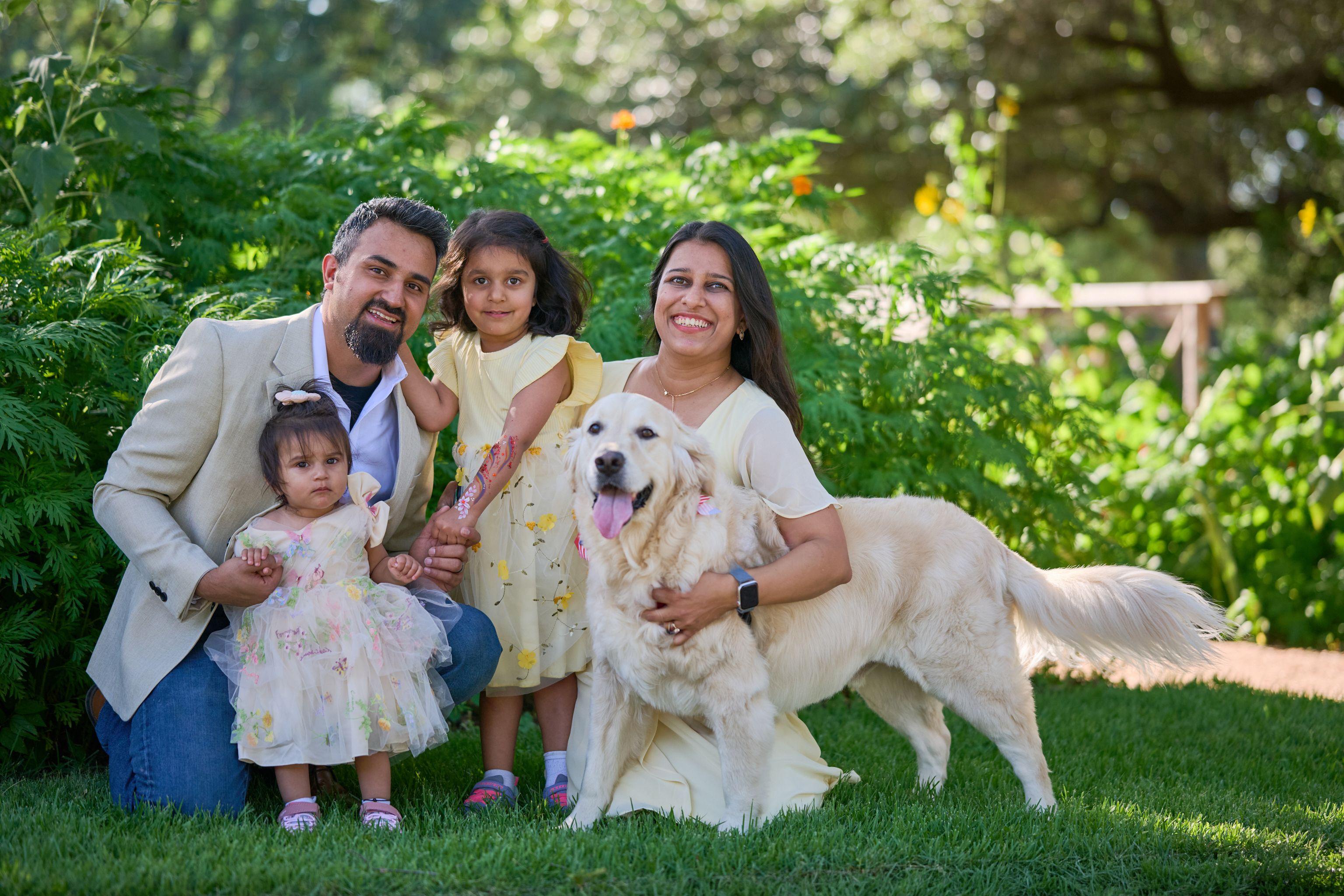 Family kneeling on a lawn around a golden retriever — Pet Photography photography, Austin A family kneeling on a lawn around a golden retriever.
