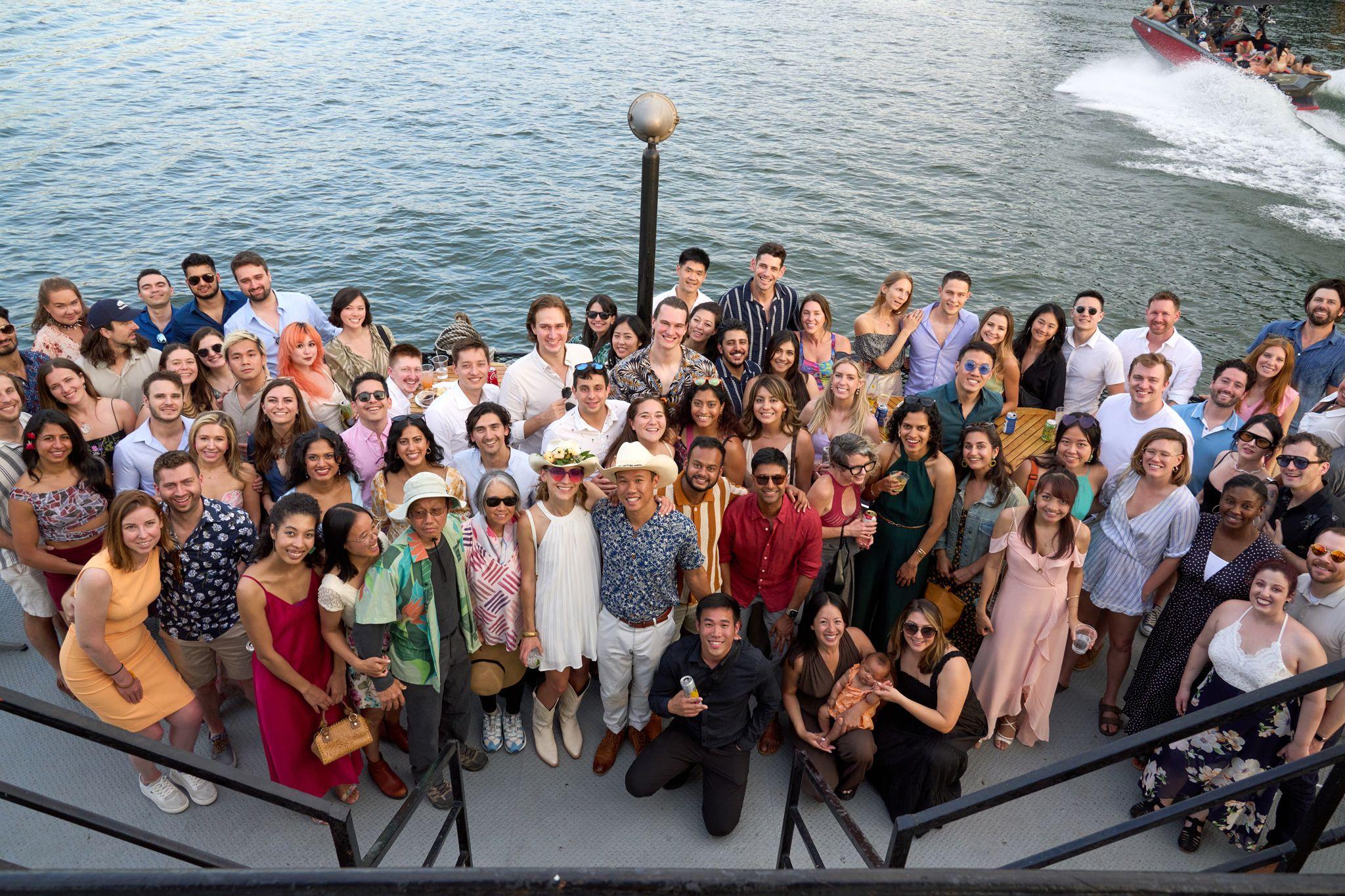 Large group photographed together on a boat deck at golden hour — Formal Celebrations photography, Austin A large group photographed together on a boat deck at golden hour.