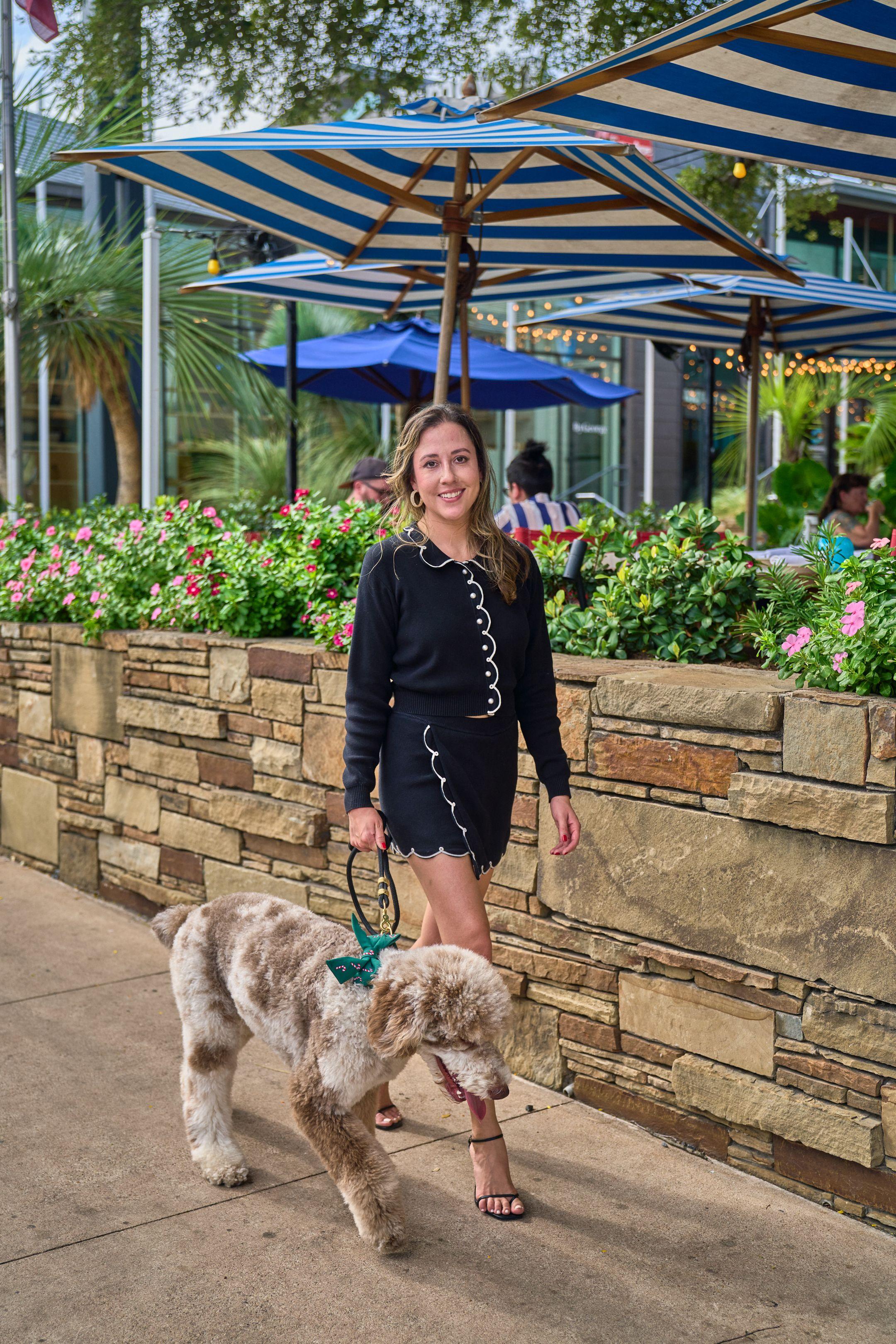 Woman and her dog beside a stone planter on a shaded restaurant patio — South Congress (SoCo) photography, Austin A woman and her dog beside a stone planter on a shaded restaurant patio.