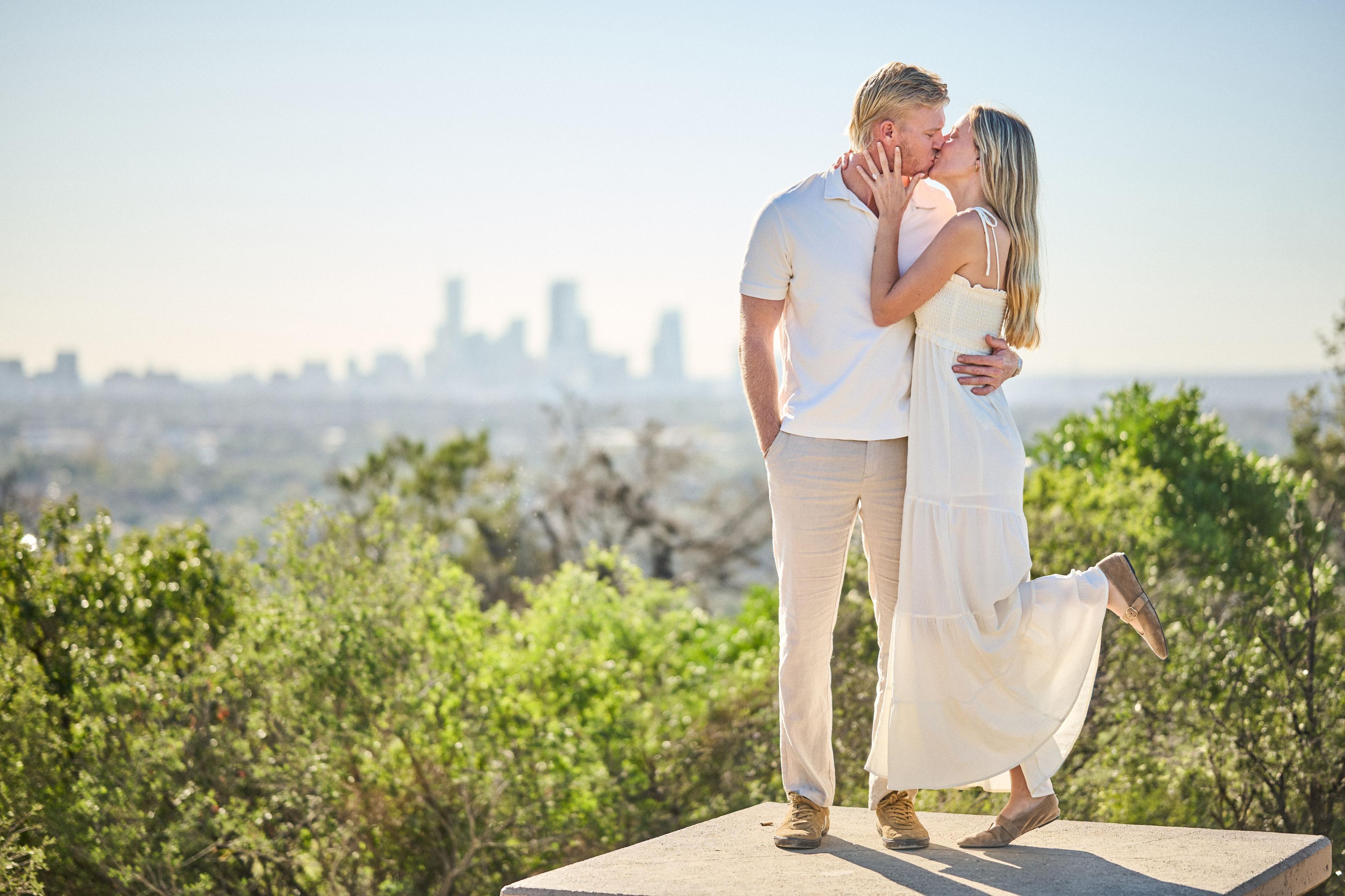 Couple kissing with the downtown Austin skyline behind them — Mount Bonnell portraits, Austin Couple kissing with the downtown Austin skyline behind them