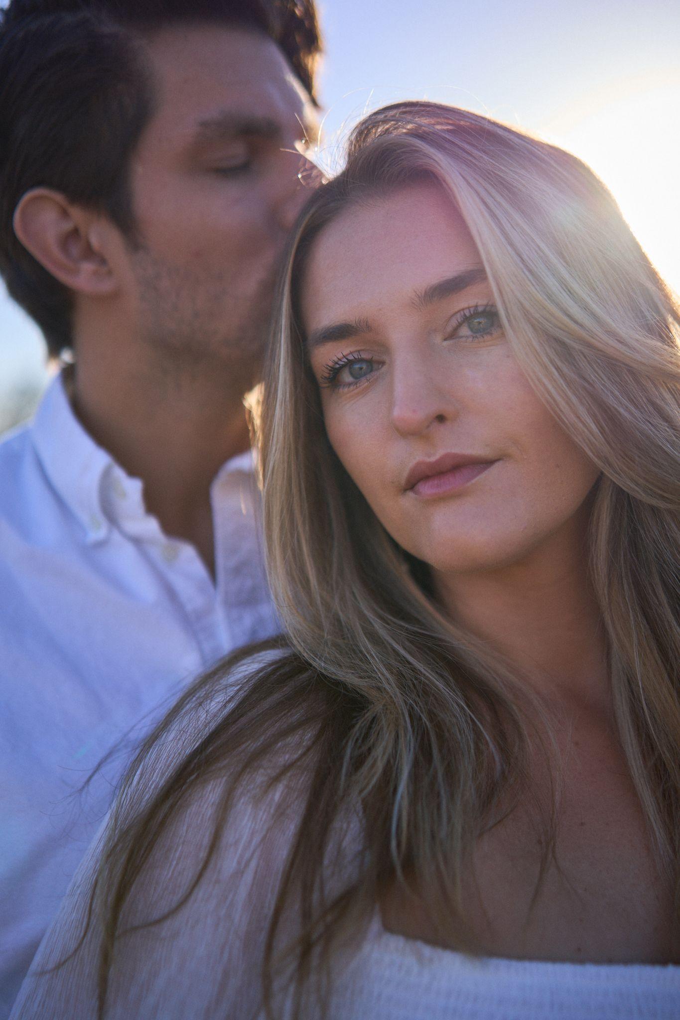 Woman leaning back against a man in the tall pale grass at Commons Ford Ranch, sun behind them — Commons Ford Ranch photography, Austin A woman leaning back against a man in the tall pale grass at Commons Ford Ranch, sun behind them