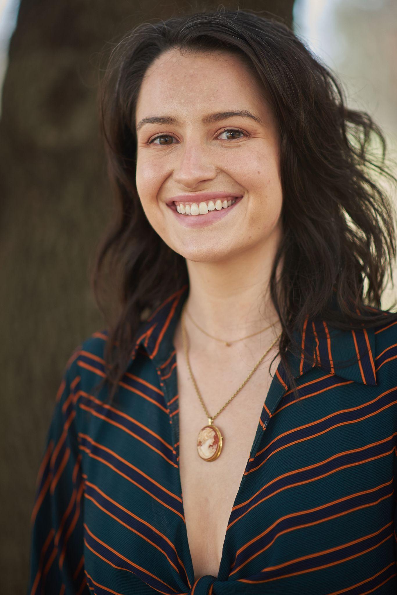 Woman in a striped shirt and pendant necklace smiling in the greenery at Pease Park — Pease Park photography, Austin A woman in a striped shirt and pendant necklace smiling in the greenery at Pease Park