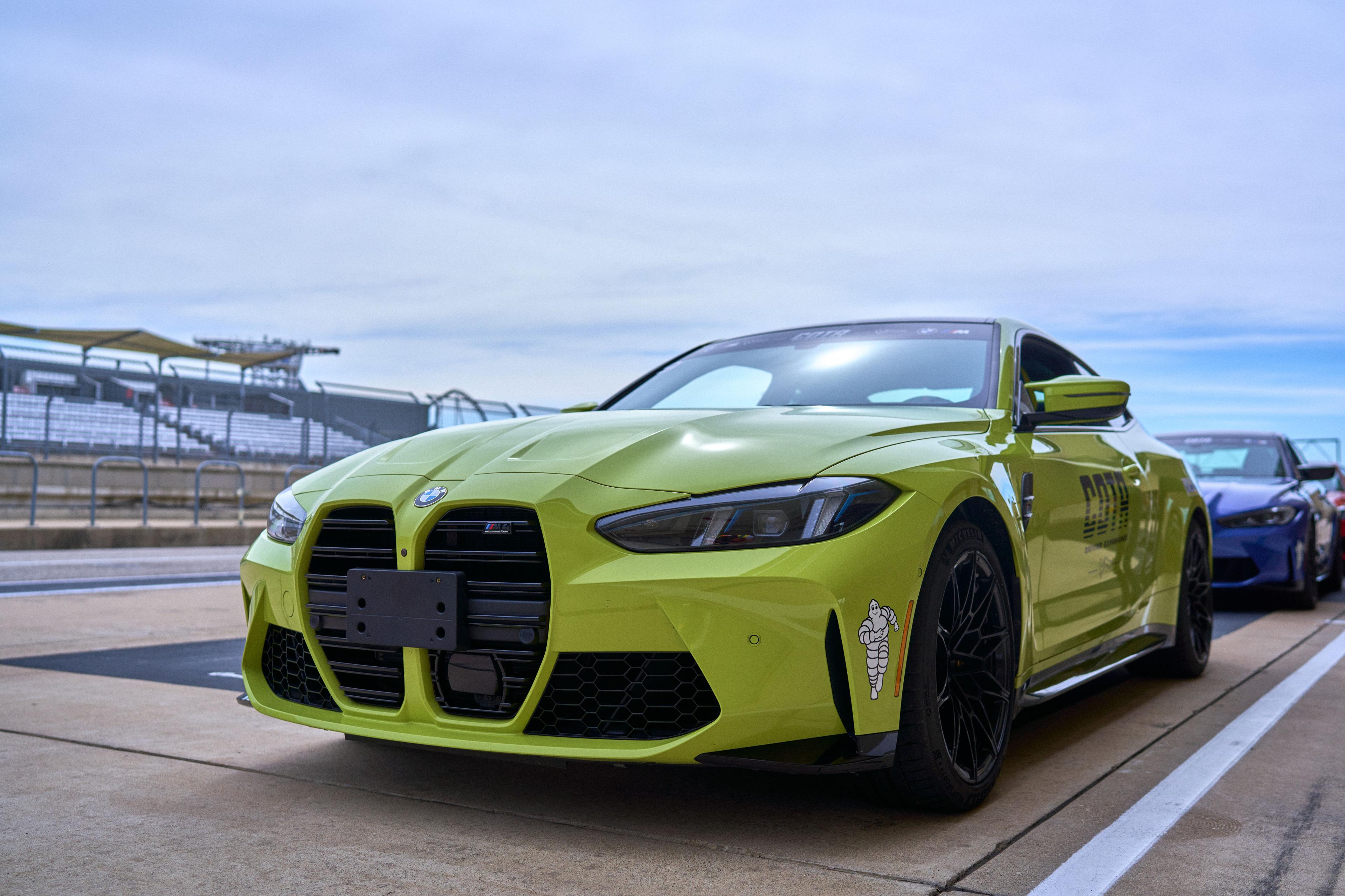 Lime green BMW M4 parked on a race circuit — Brand activation photography, Austin A lime green BMW M4 parked on a race circuit.