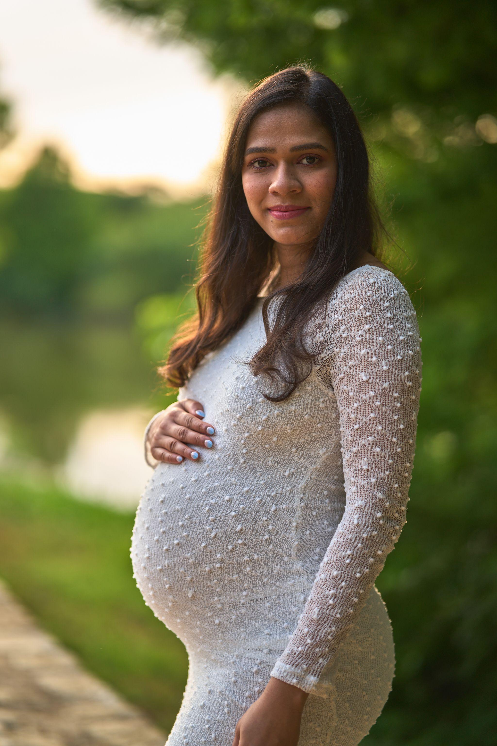 Expectant mother in a white dress at golden hour by a lake — Maternity photography, Austin Expectant mother in a white dress at golden hour by a lake