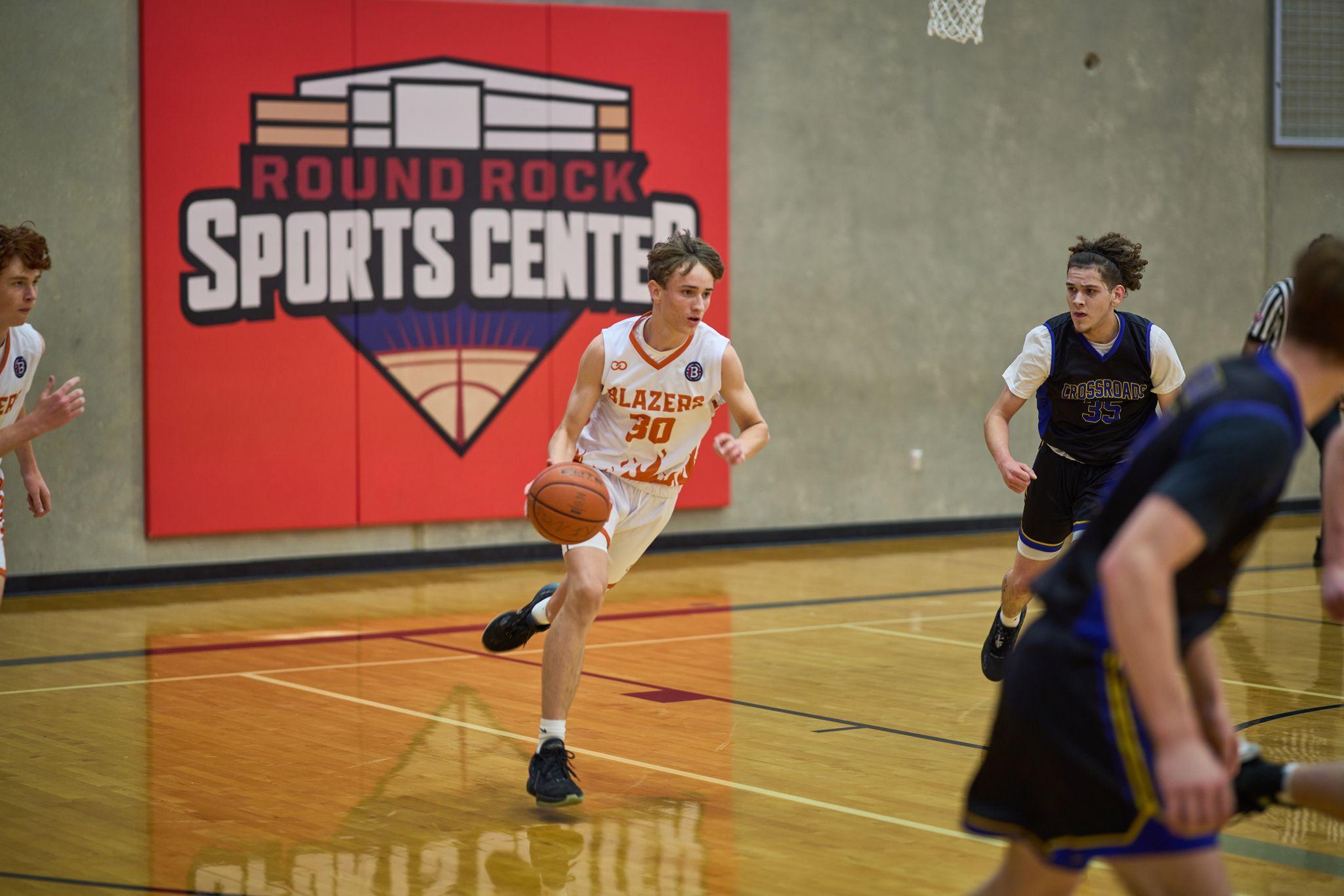 Basketball player driving the ball up court in a school gym — Sports photography, Austin Basketball player driving the ball up court in a school gym