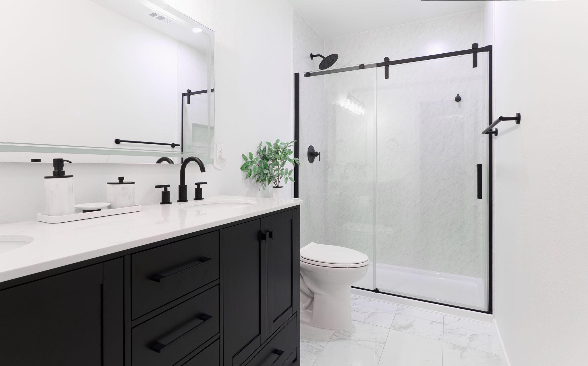 Modern bathroom with black cabinetry, a glass shower and matte black fixtures — Architectural photography, Austin A modern bathroom with black cabinetry, a glass shower and matte black fixtures.