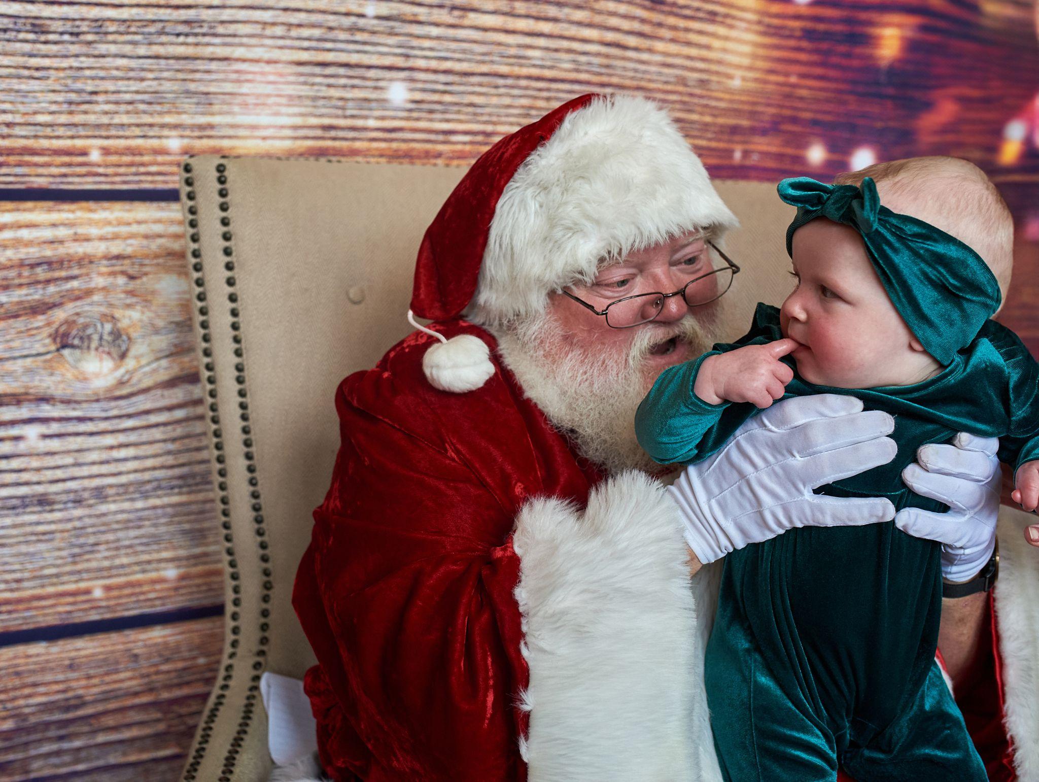 Baby reaching up to Santa's beard as Santa laughs — Seasonal Christmas & Fall photography, Austin A baby reaching up to Santa's beard as Santa laughs.