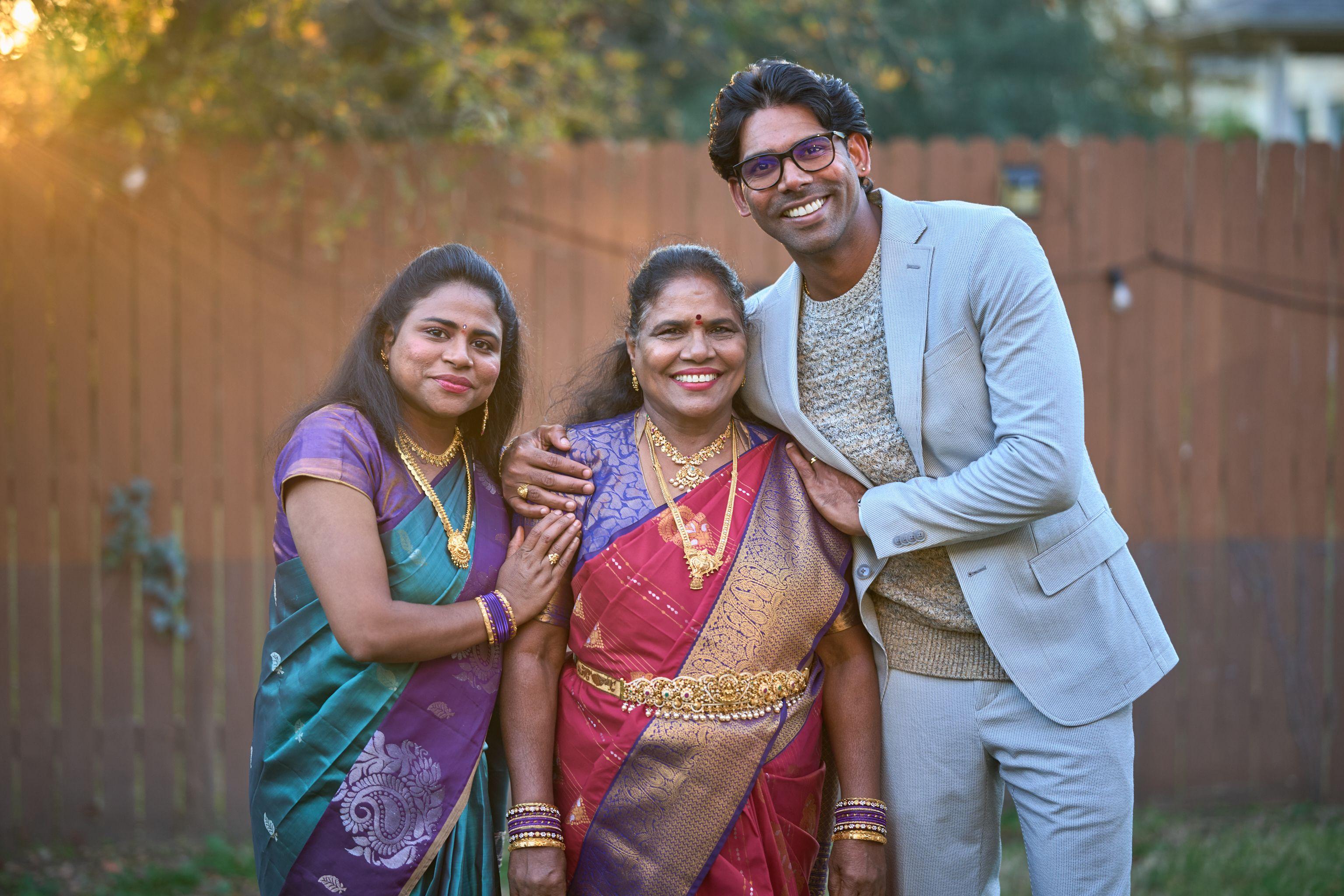 Three family members in silk saris and a pale suit standing together after a ceremony — Religious Ceremonies photography, Austin Three family members in silk saris and a pale suit standing together after a ceremony.